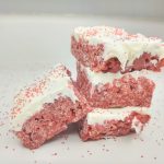 stack of red velvet cake rice krispie treats with cream cheese icing and red sprinkles
