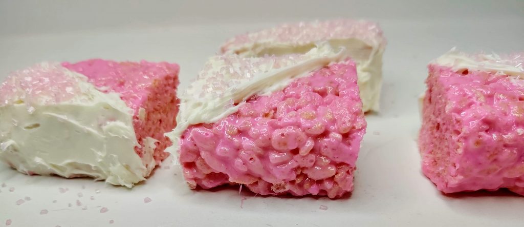 pink baby shower rice krispie treats in a line