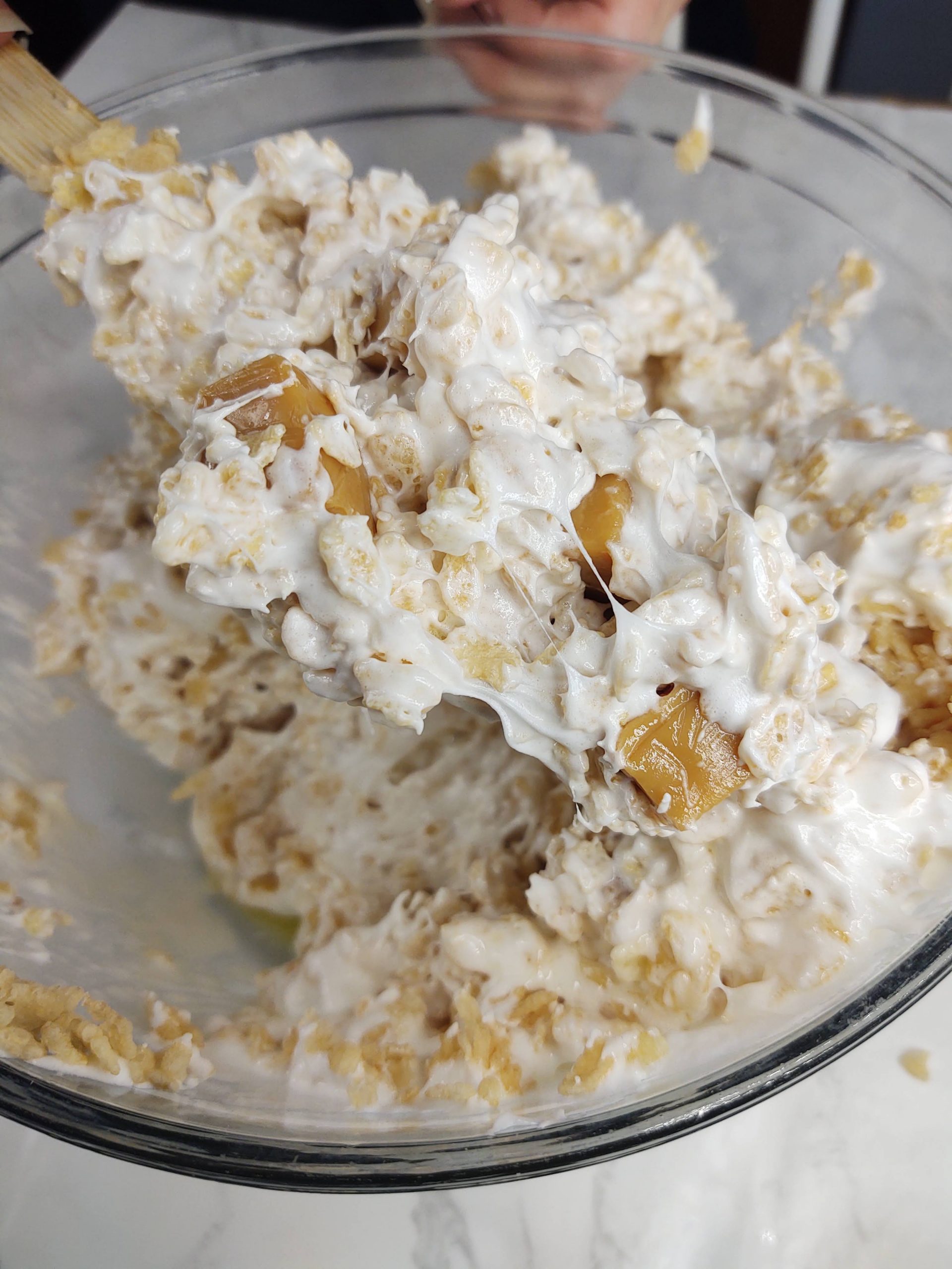 mixing caramel candies into cereal and marshmallows