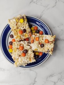 three reeses pieces rice krispie treats on a plate
