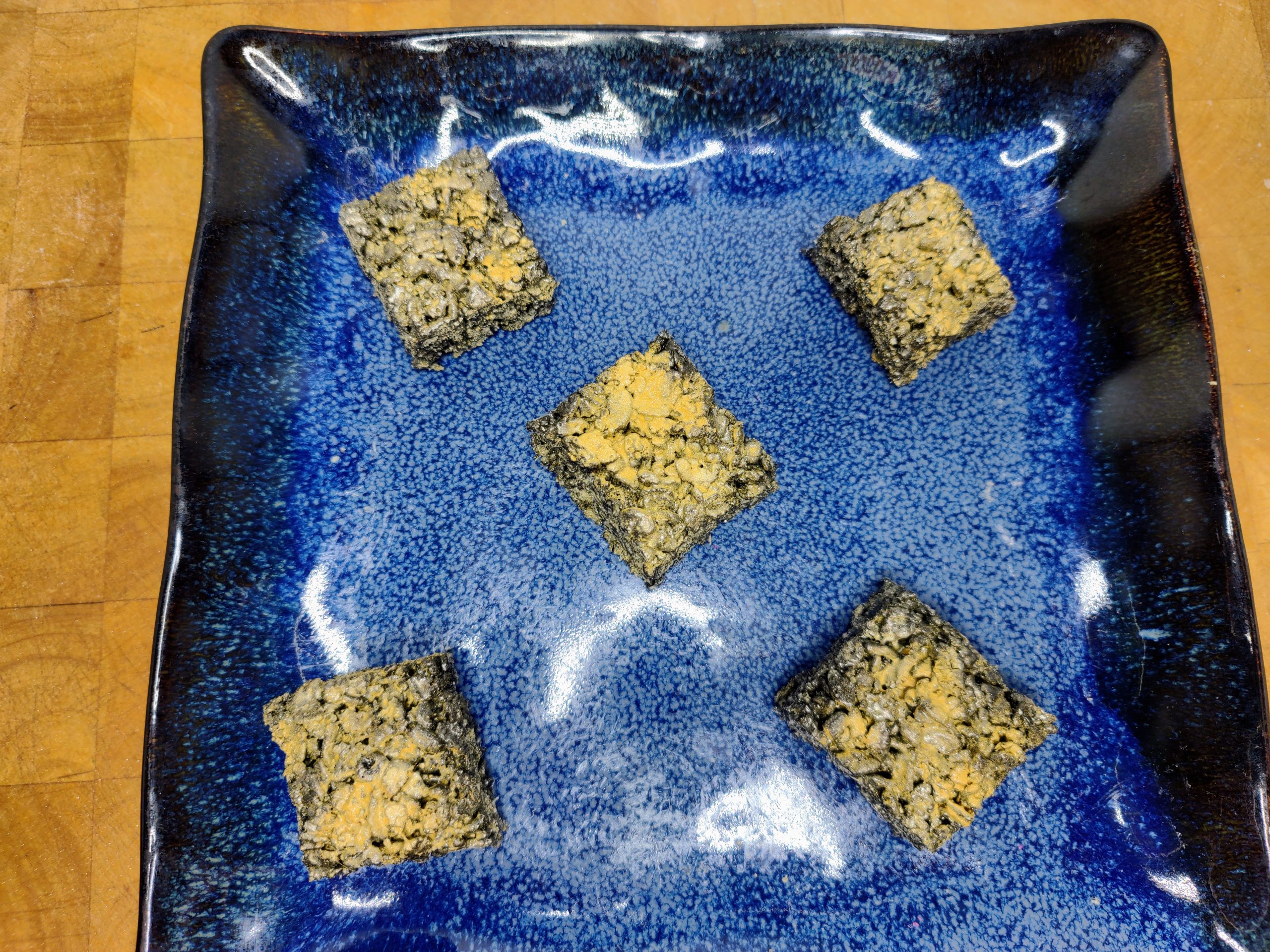 plate of five black and gold rice krispie treats