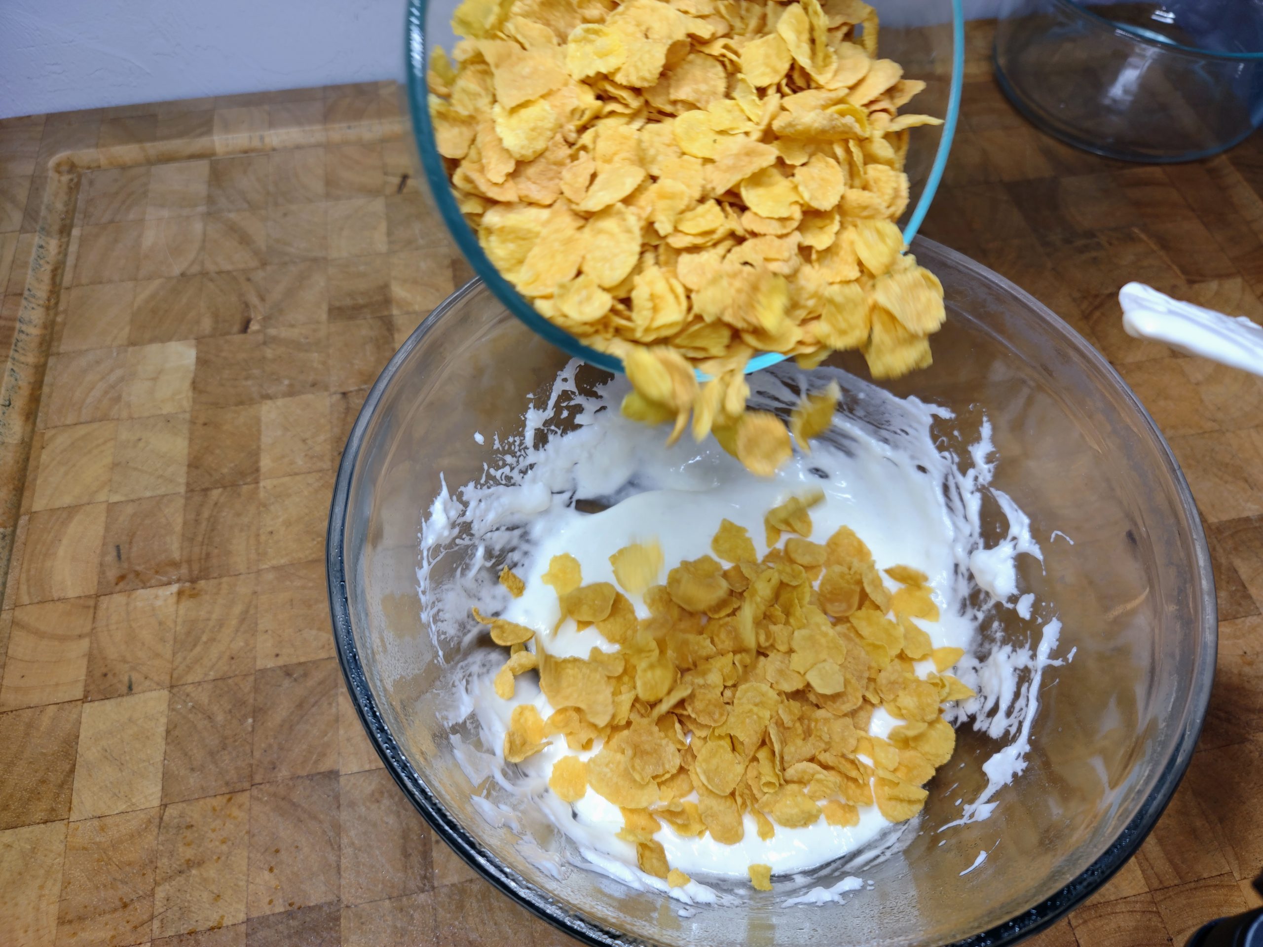 adding corn flakes into melted marshmallows