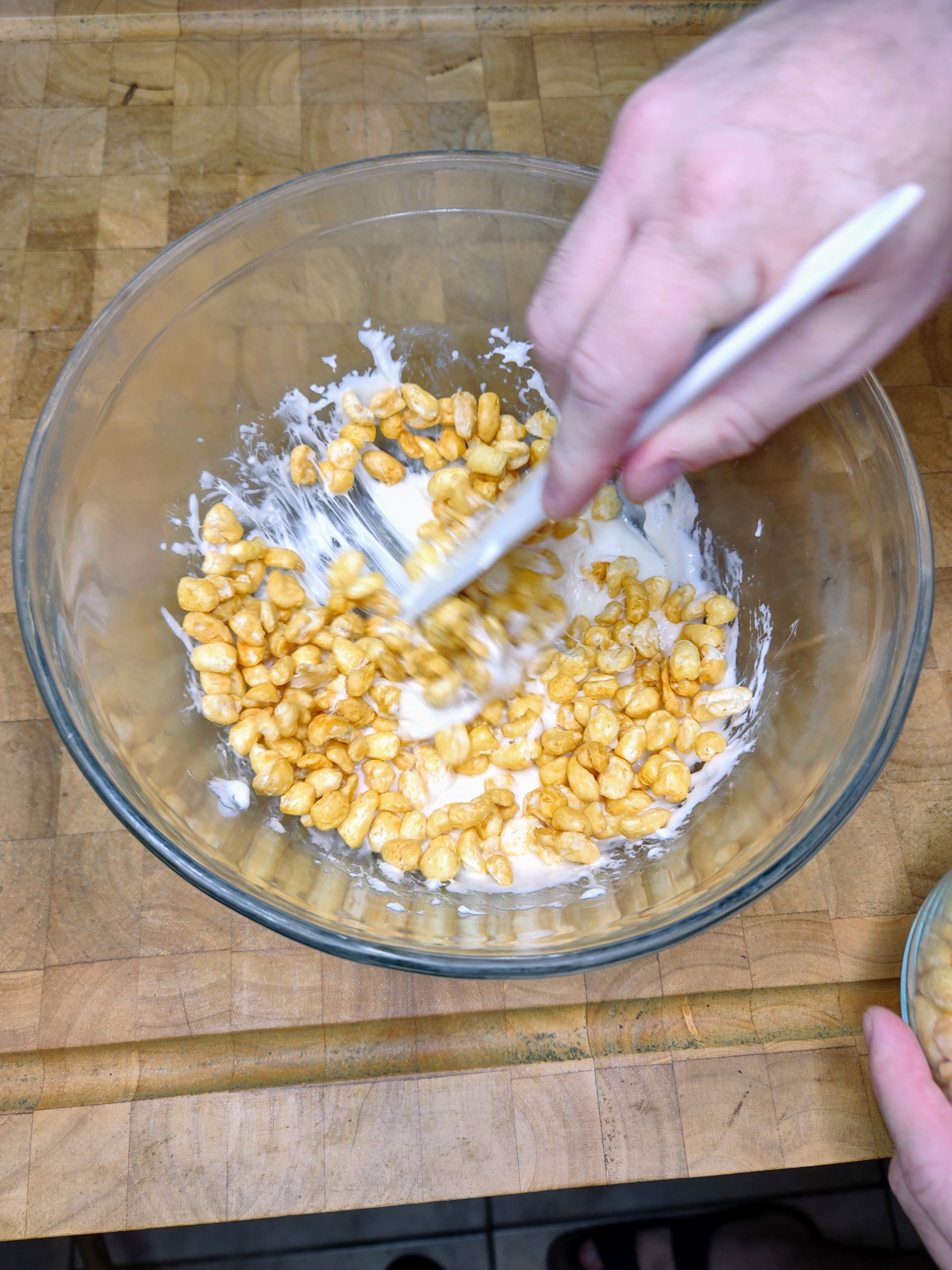 stirring corn pops into melted marshmallows