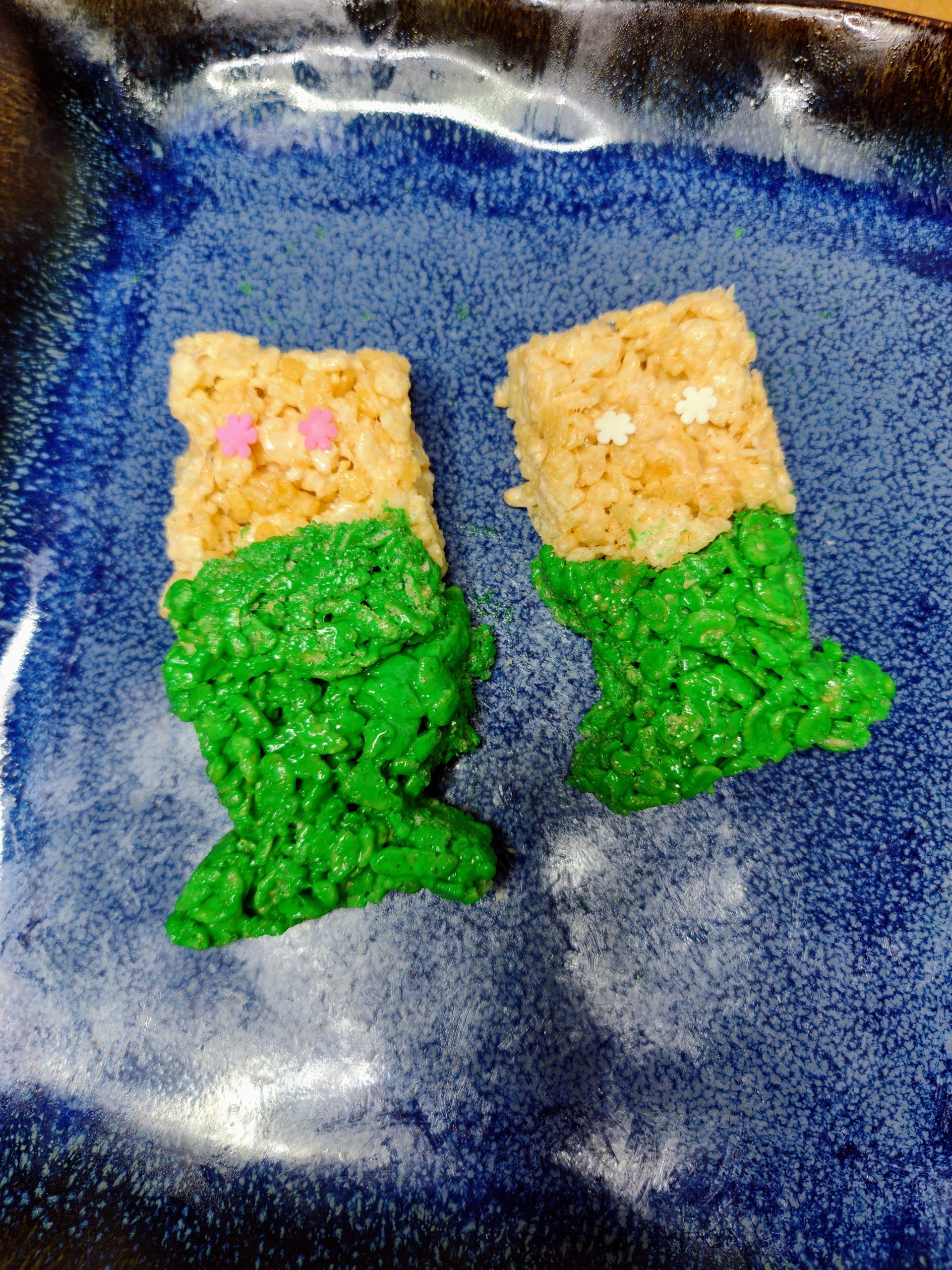 two mermaid rice krispie treats on a plate