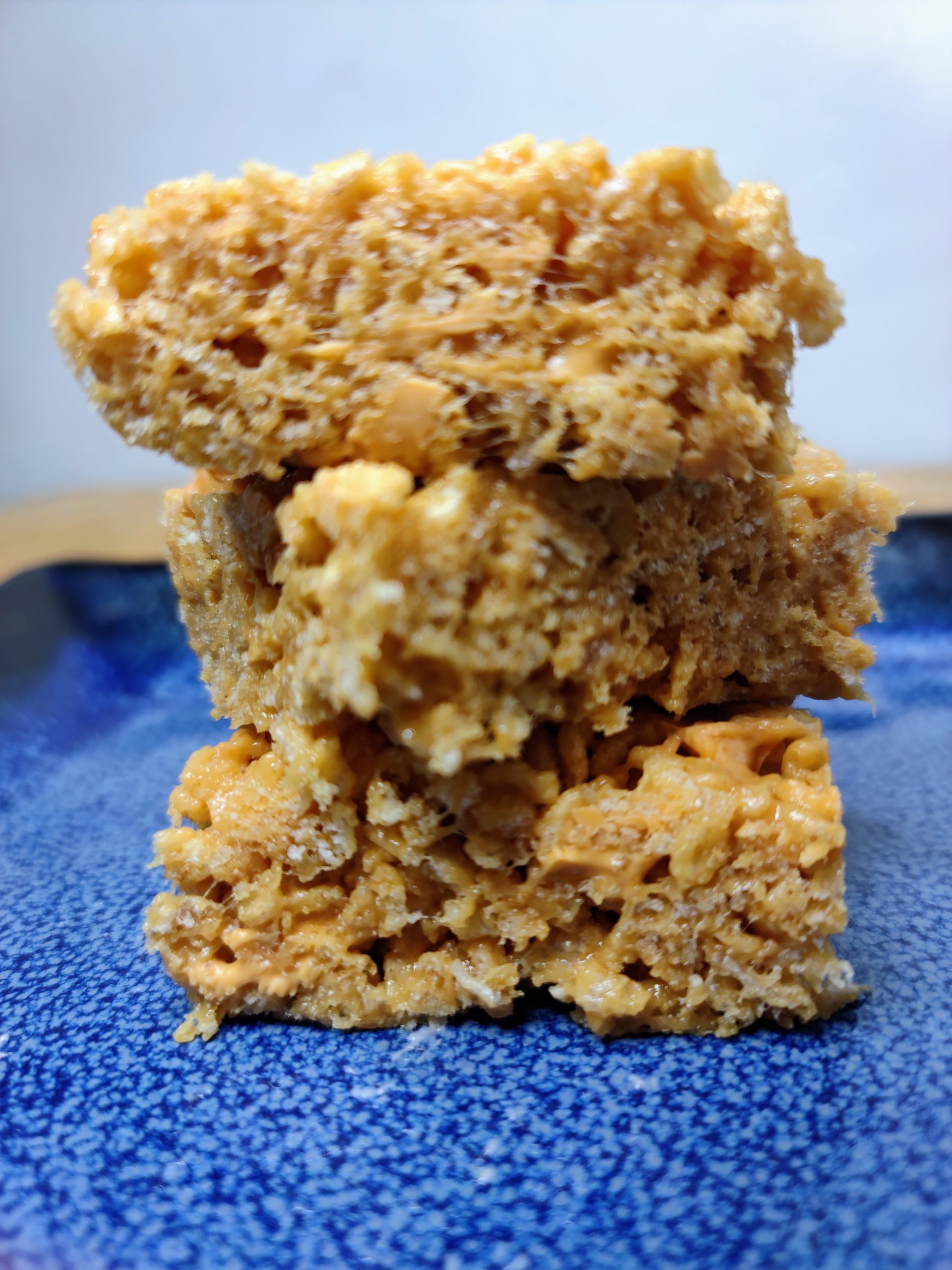 three peanut butter butterscotch rice krispie treats stacked on each other