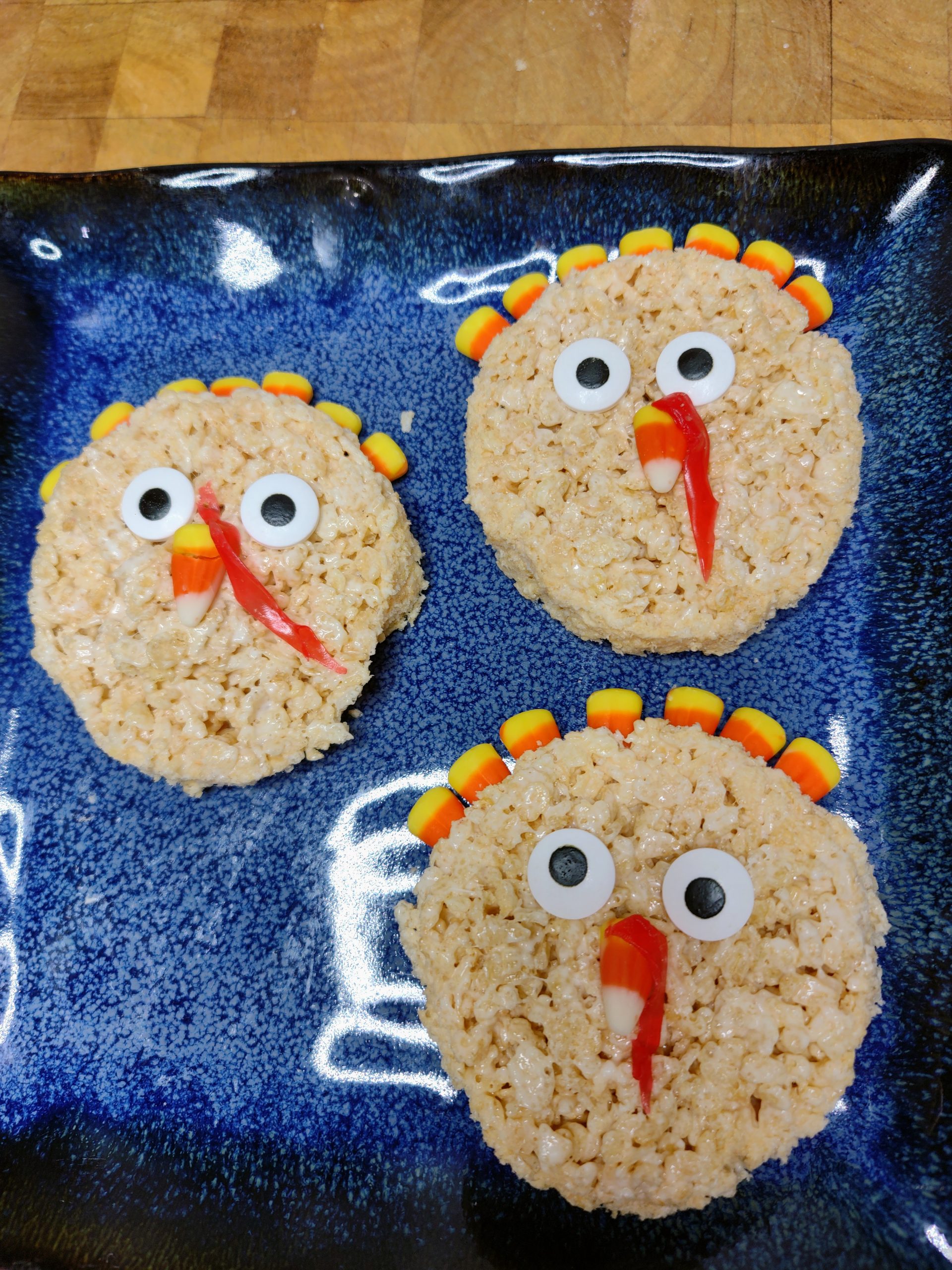 three turkey rice krispie treats on a blue plate