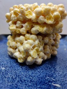Two Kix Cereal Treats stacked on a blue plate