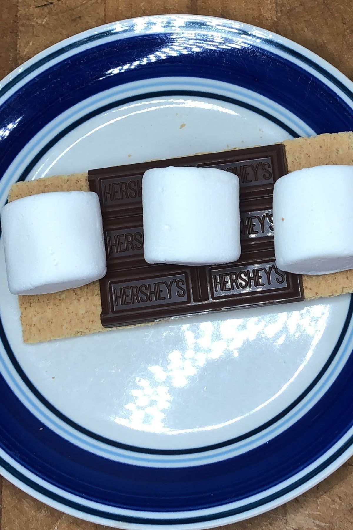Plate with graham crackers, chocolate bars and marshmallows.