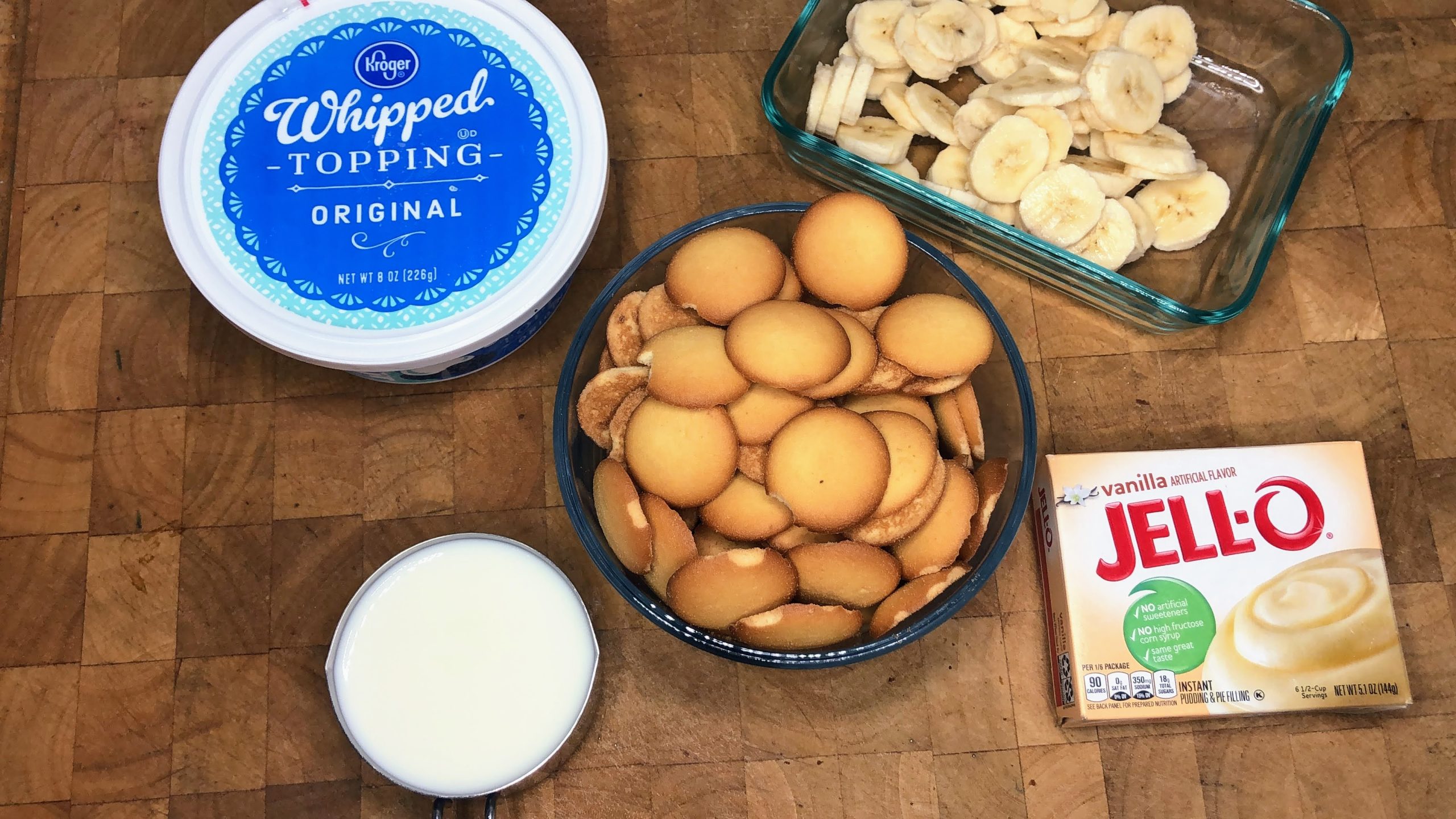 Bowls of vanilla pudding, milk, nilla wafers, sliced bananas and whipped topping.