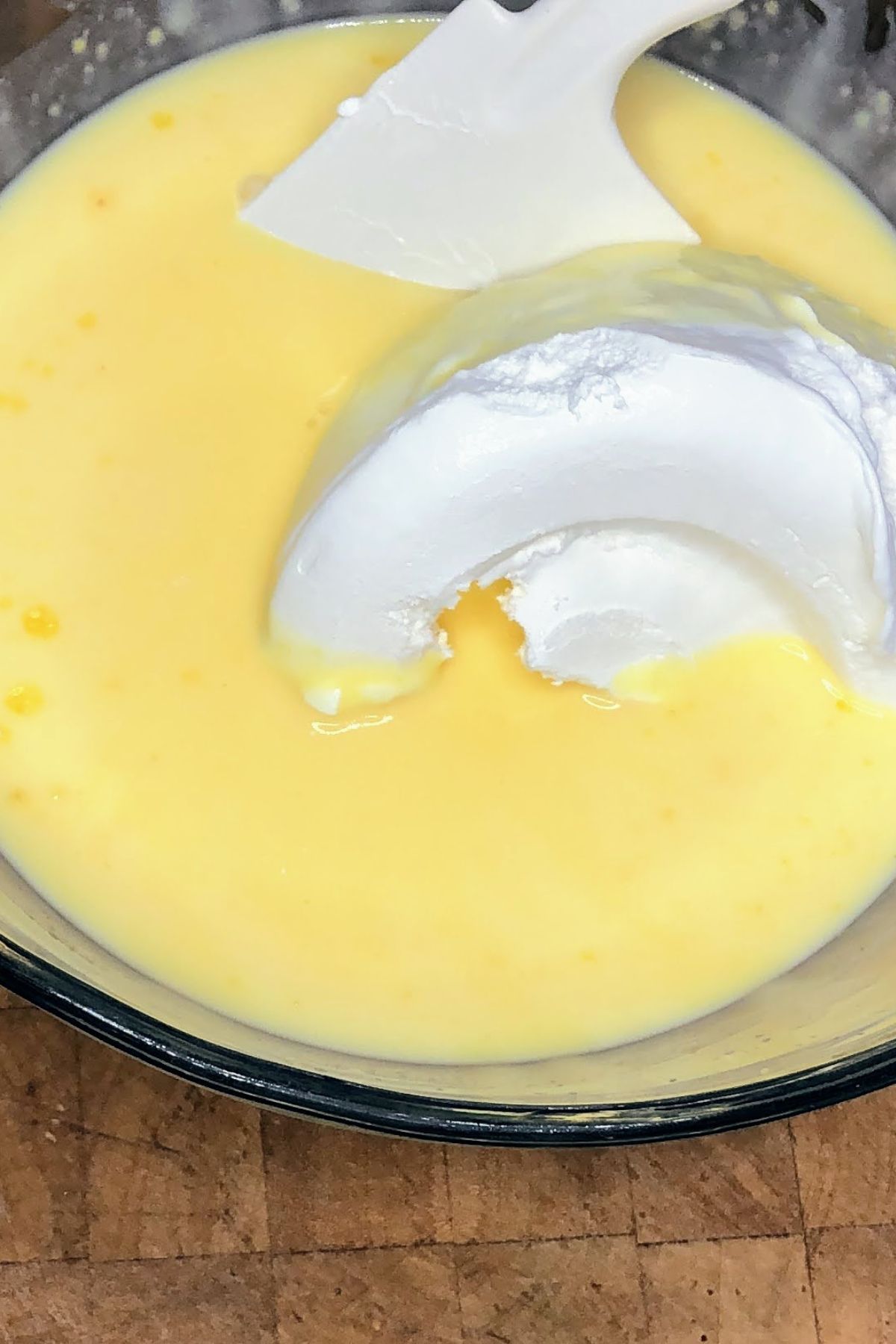 Adding whipped topping to vanilla pudding.