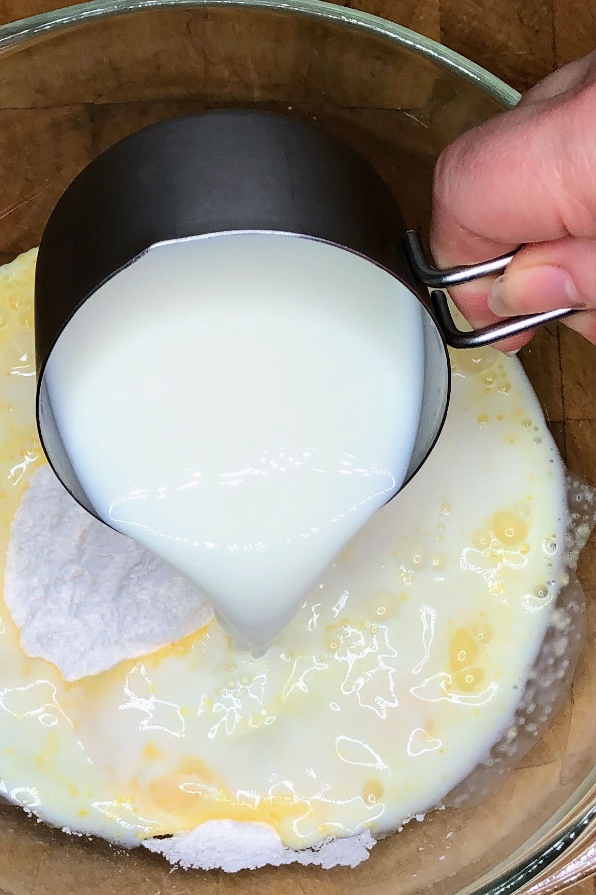 Pouring milk into vanilla pudding mix.