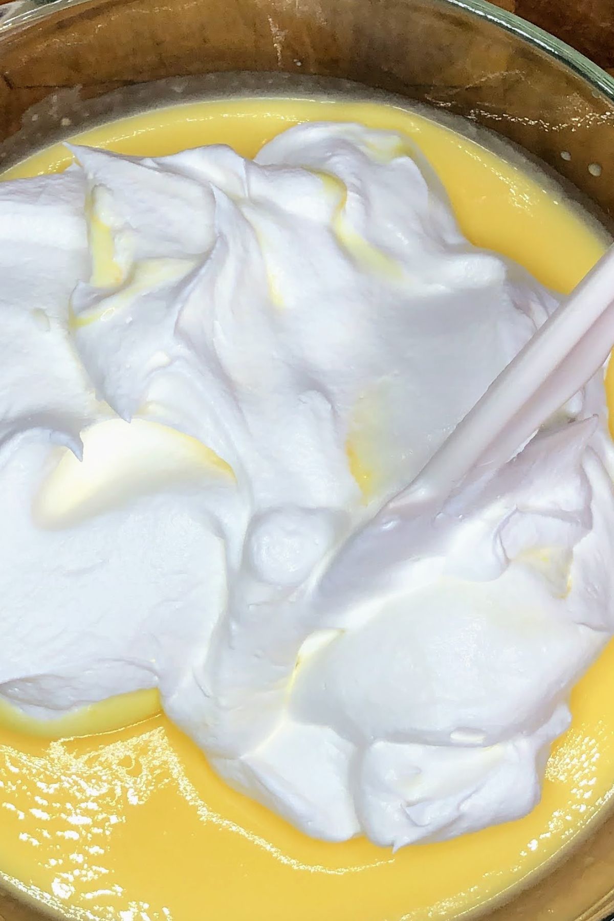 Stirring whipped topping into vanilla pudding.