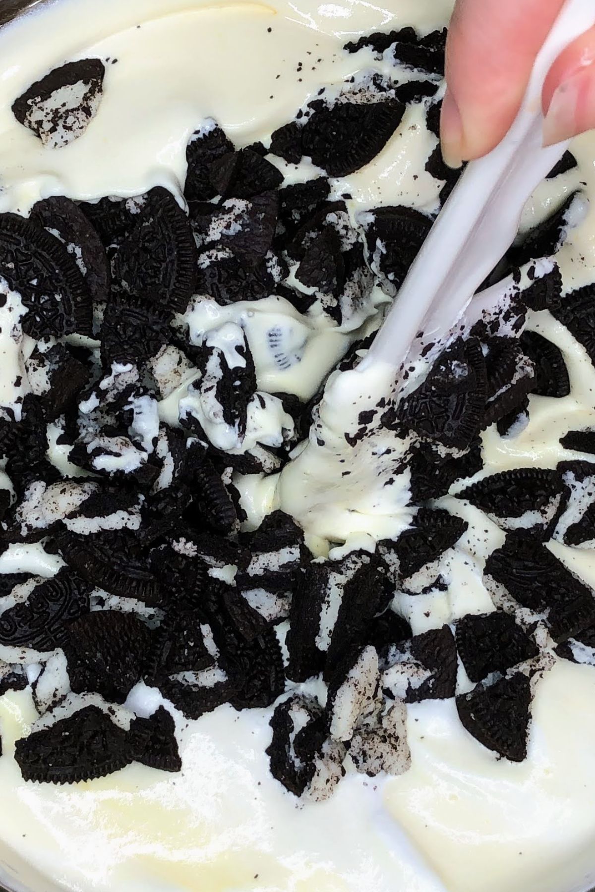 Stirring crumbled oreos into fluff.