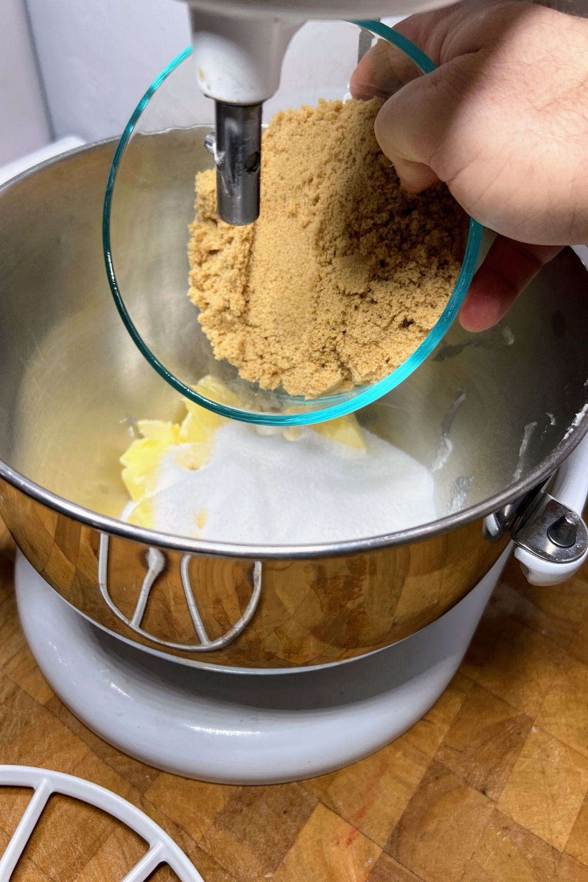 Adding brown sugar to a mixing bowl.