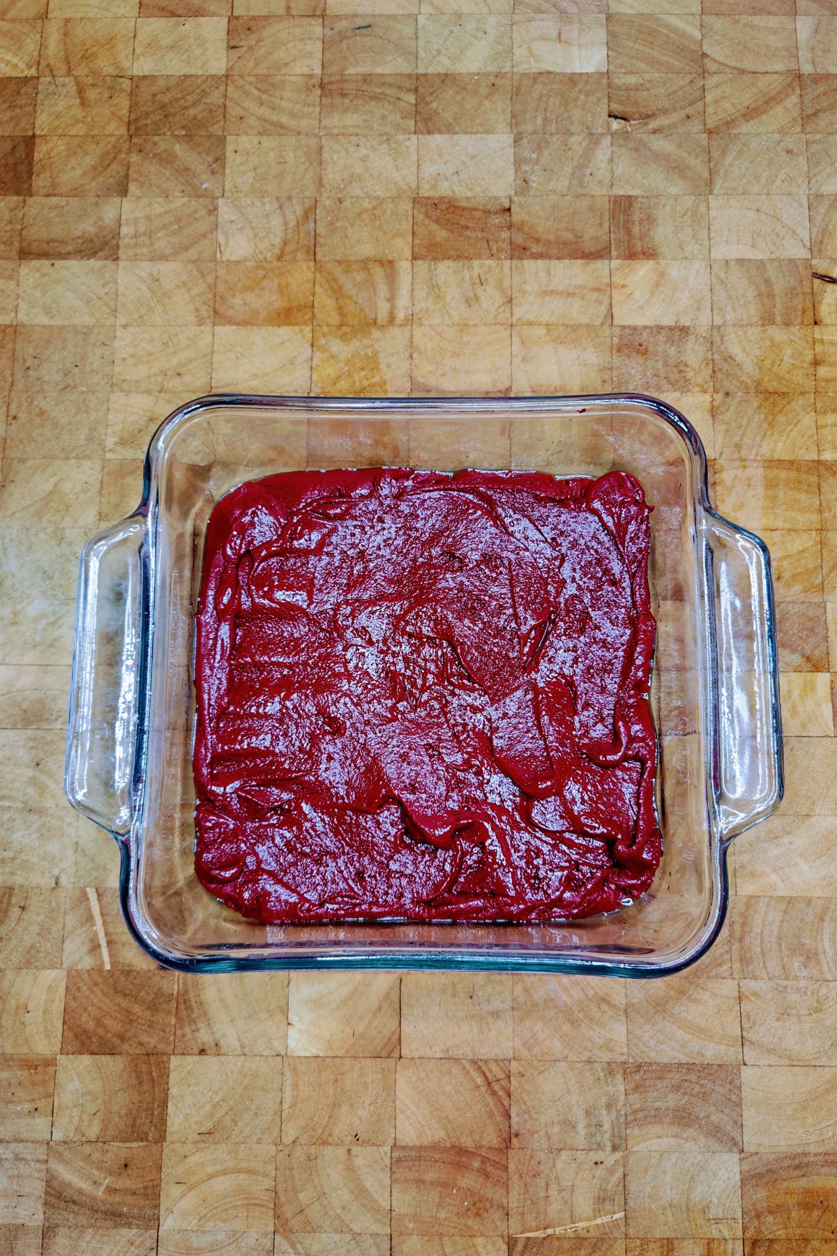 Red velvet cake mix brownie batter in a baking pan.