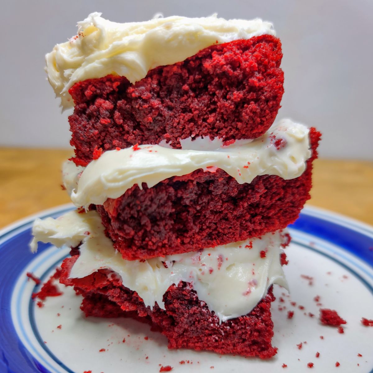 Stack of red velvet cake mix brownies on a plate with cream cheese frosting.