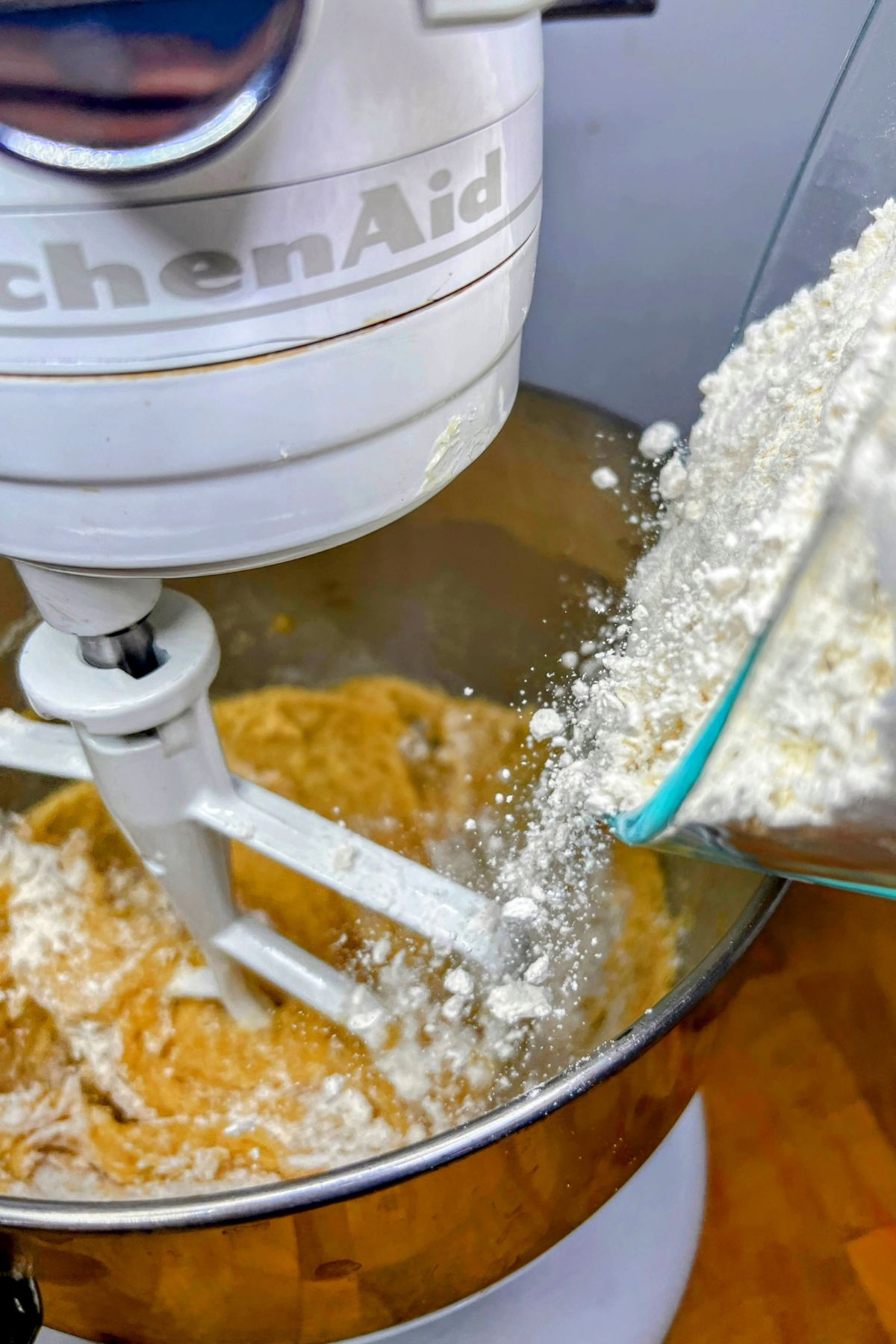 Pouring flour into cookie dough.