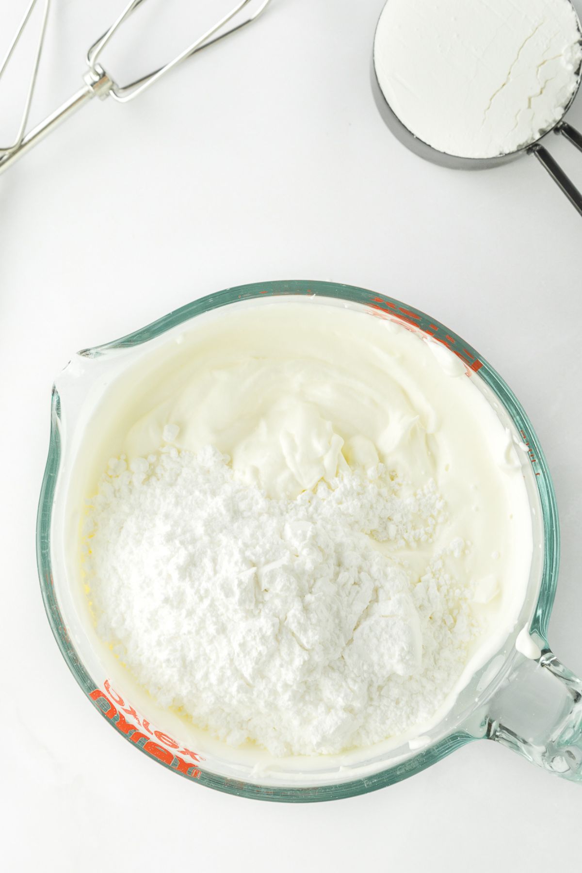 Mixing powdered sugar into whipped cream.