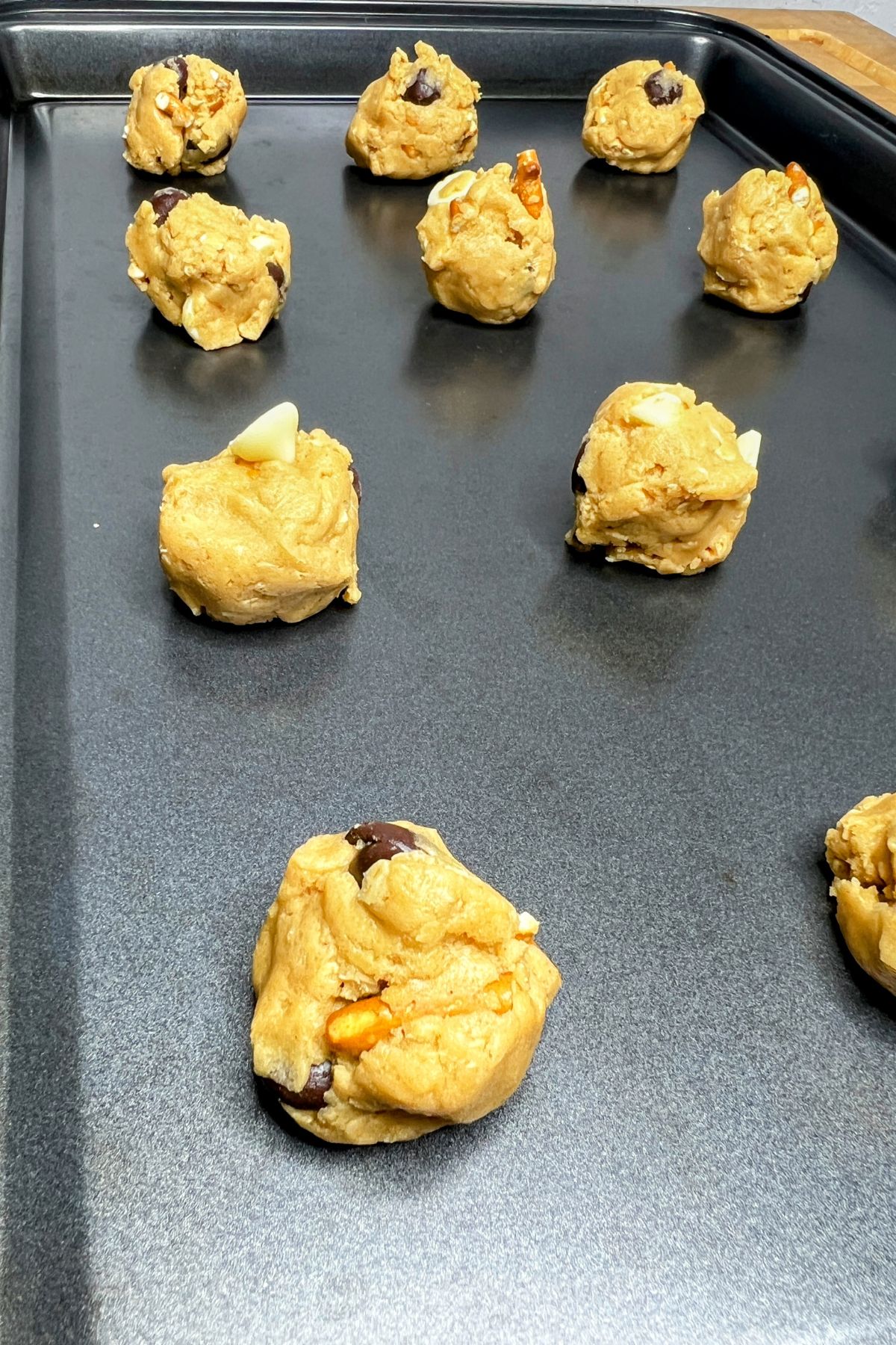 Balls of everything cookie dough on a cookie sheet.