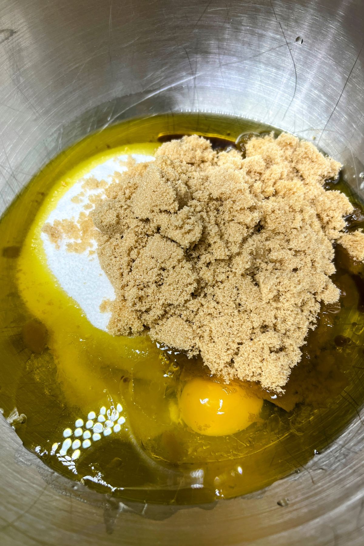 Bowl with oil, eggs, white and brown sugar.