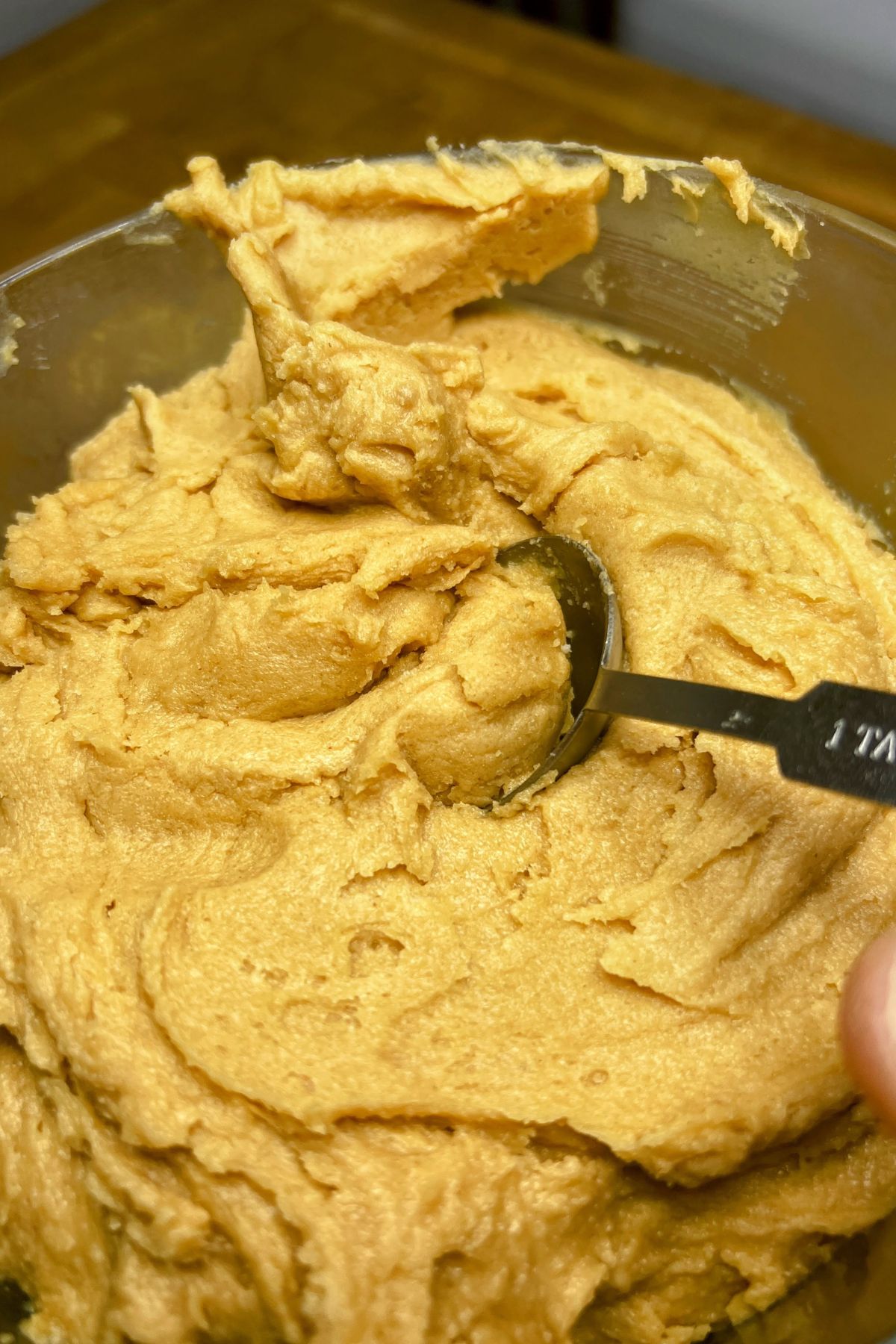 Scooping peanut butter pancake mix cookie dough with a spoon.