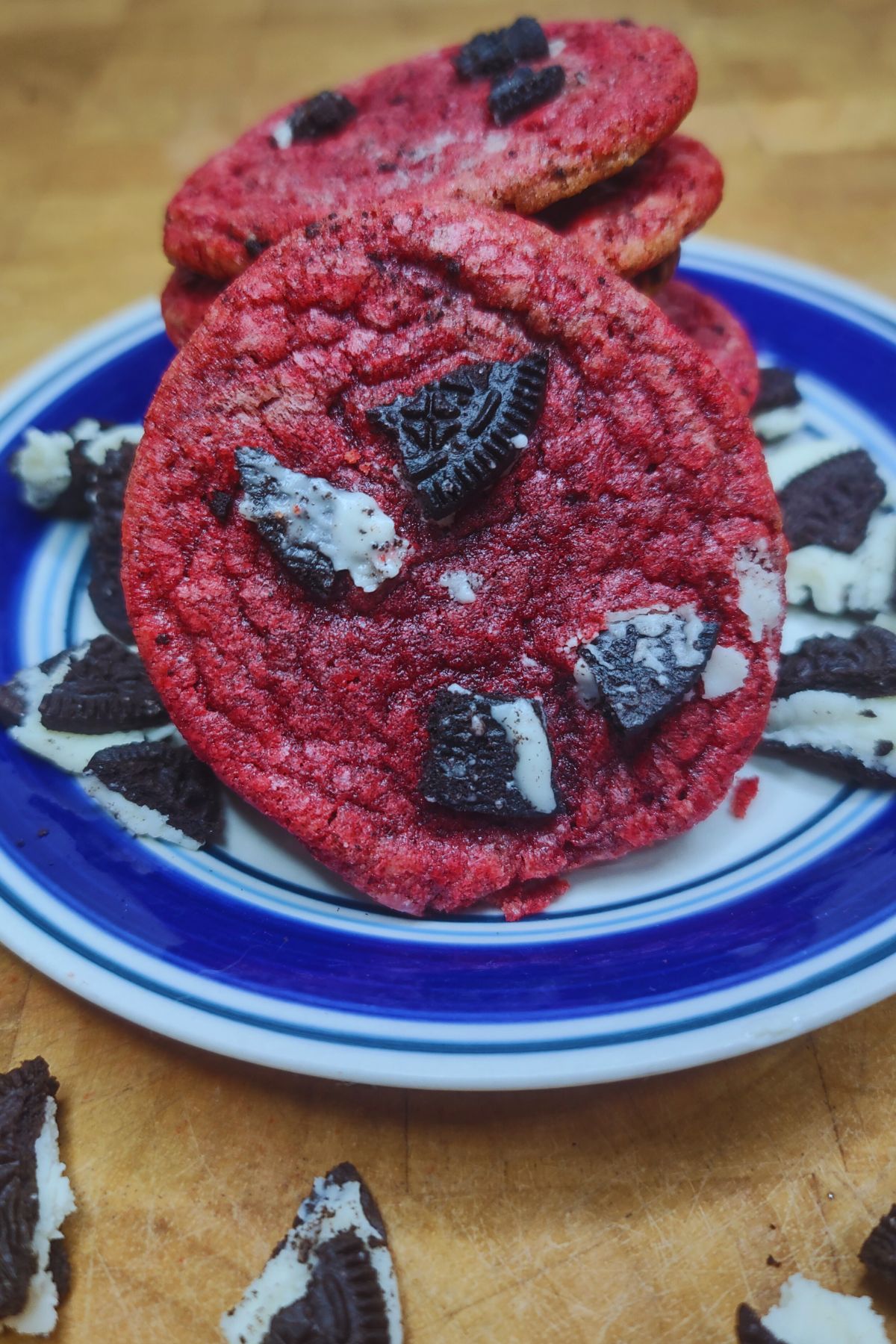 Stack of oreo red velvet cookies on a blue and white plate.