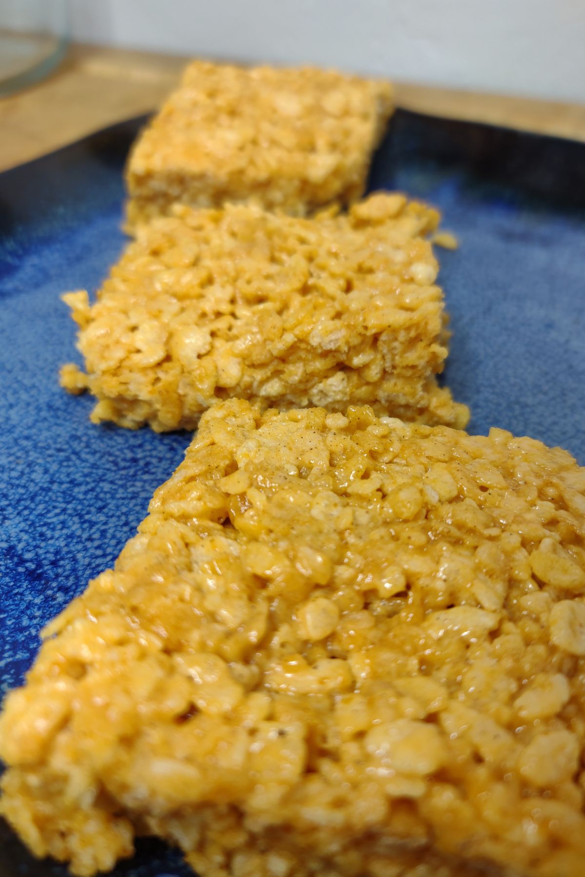 Three pumpkin spice rice krispie treats on a plate.