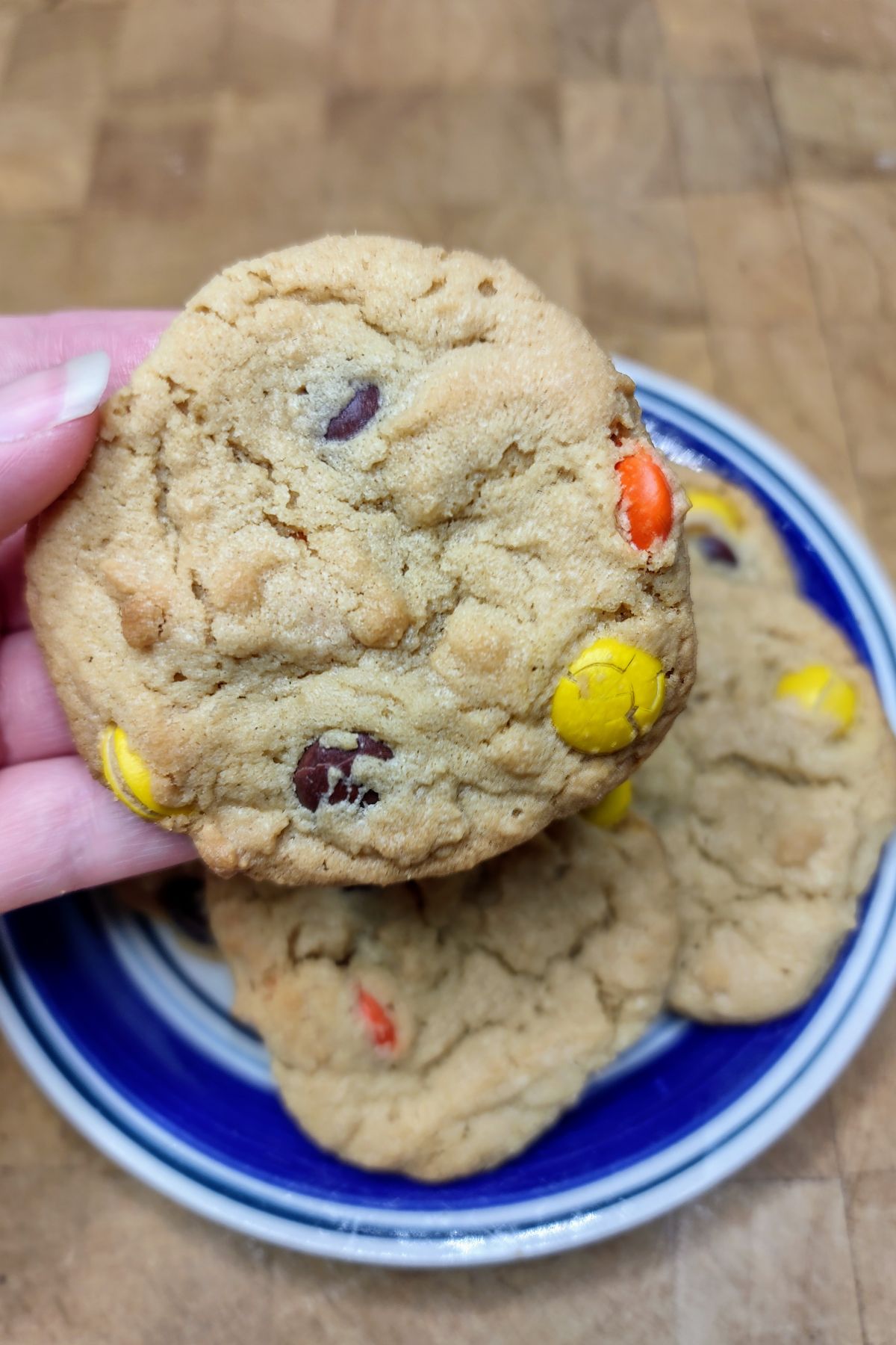 Reeses pieces cookies being held by a hand.