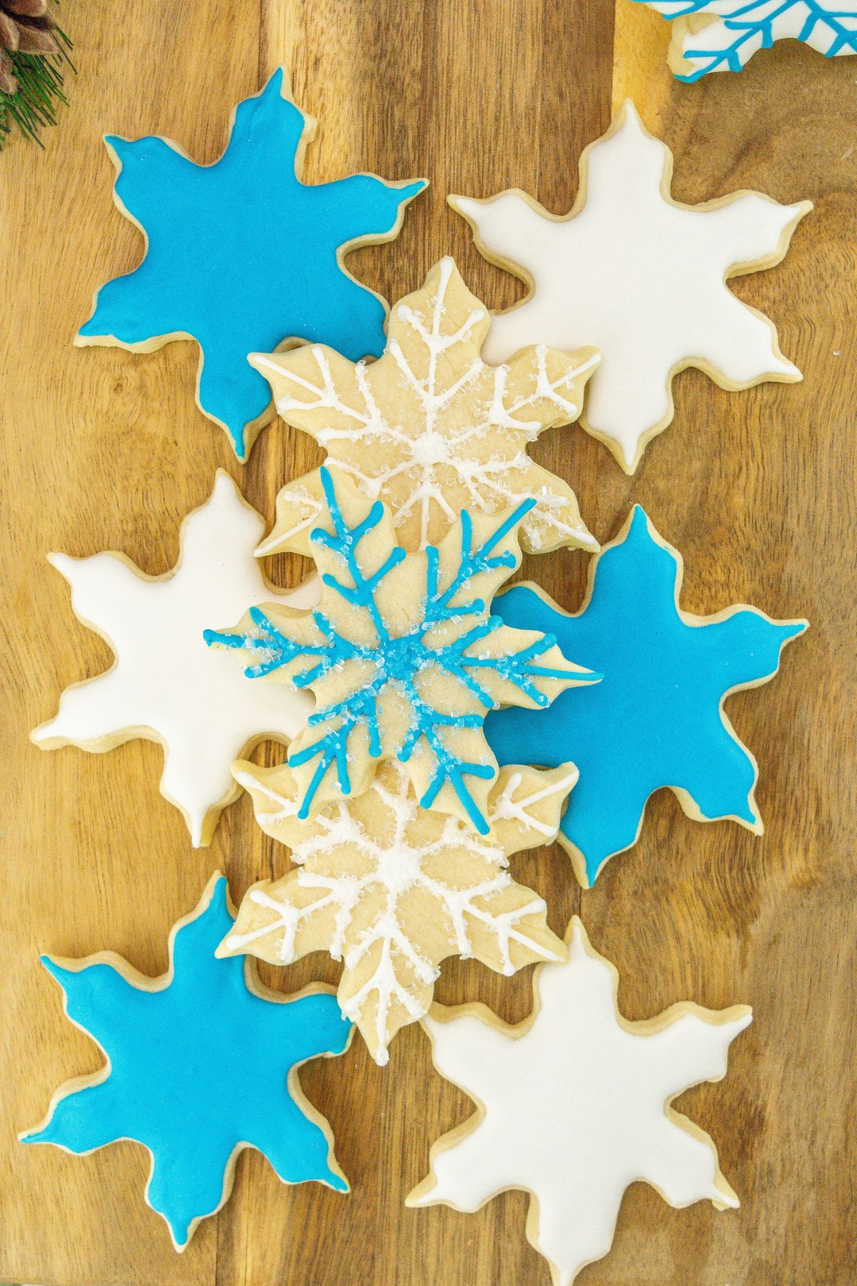 Snowflake sugar cookies on a wooden cutting board.