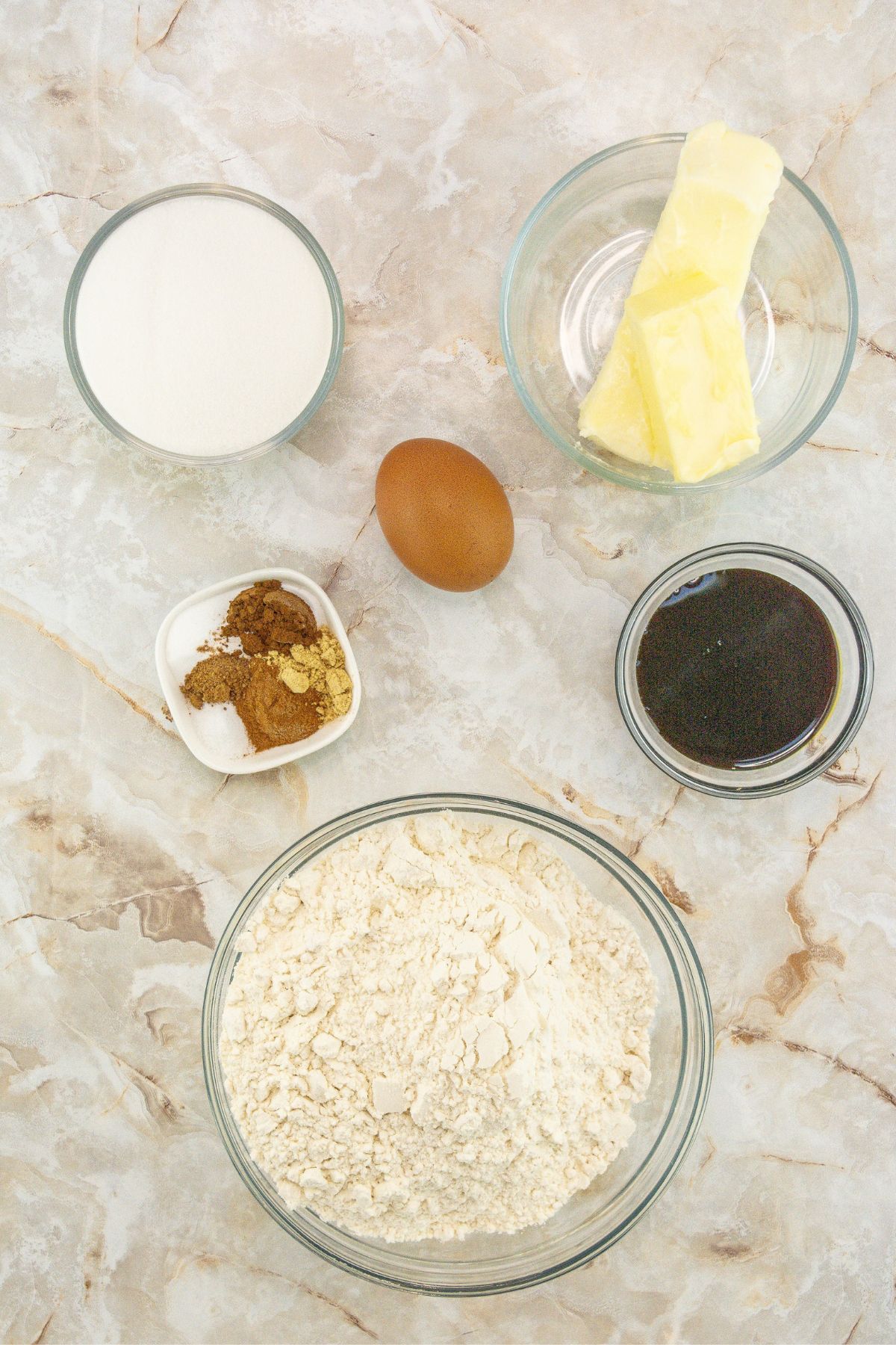 Chewy gingersnap cookie ingredients on a white marble table.