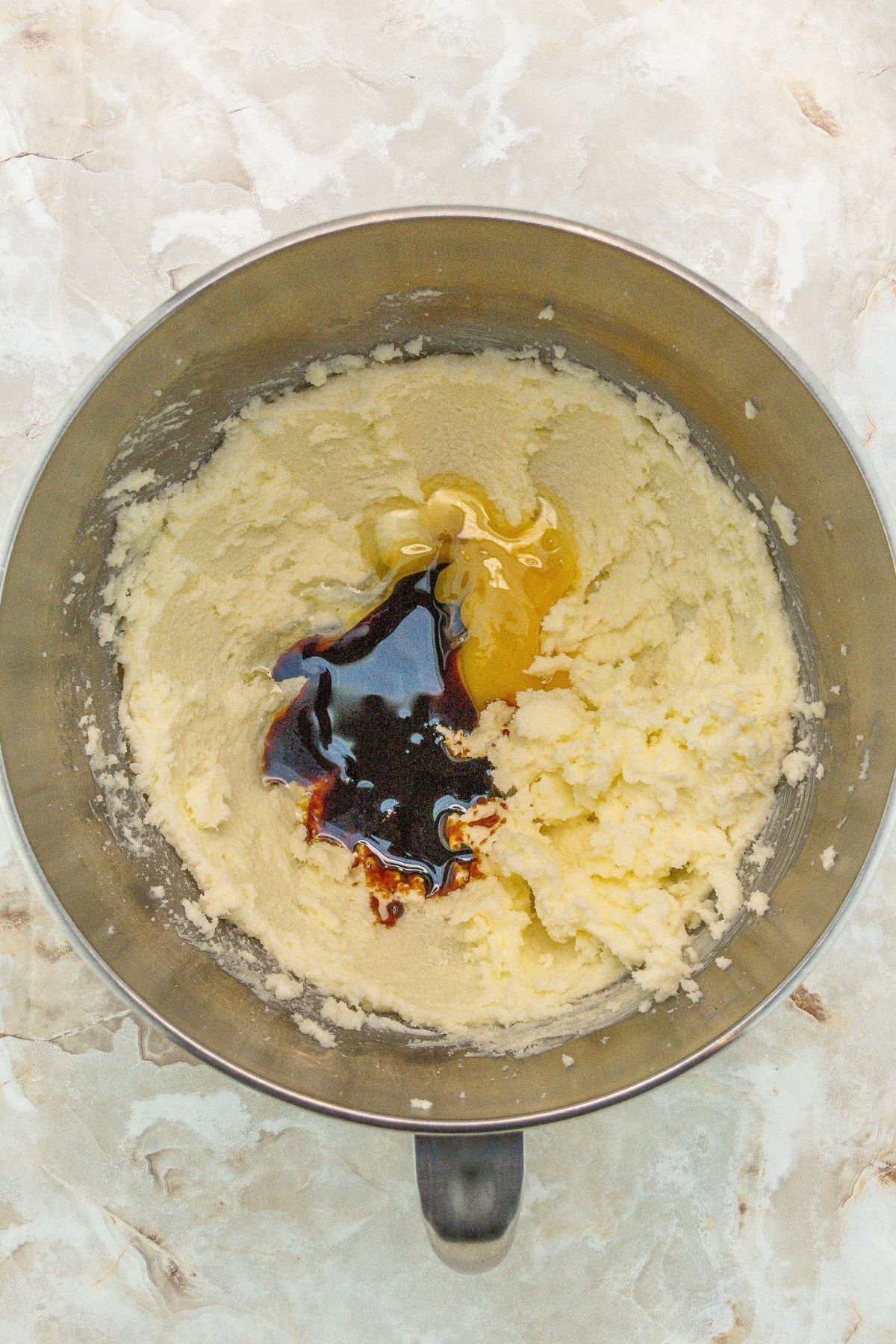 Mixing bowl with eggs, vanilla and creamed butter and sugar.