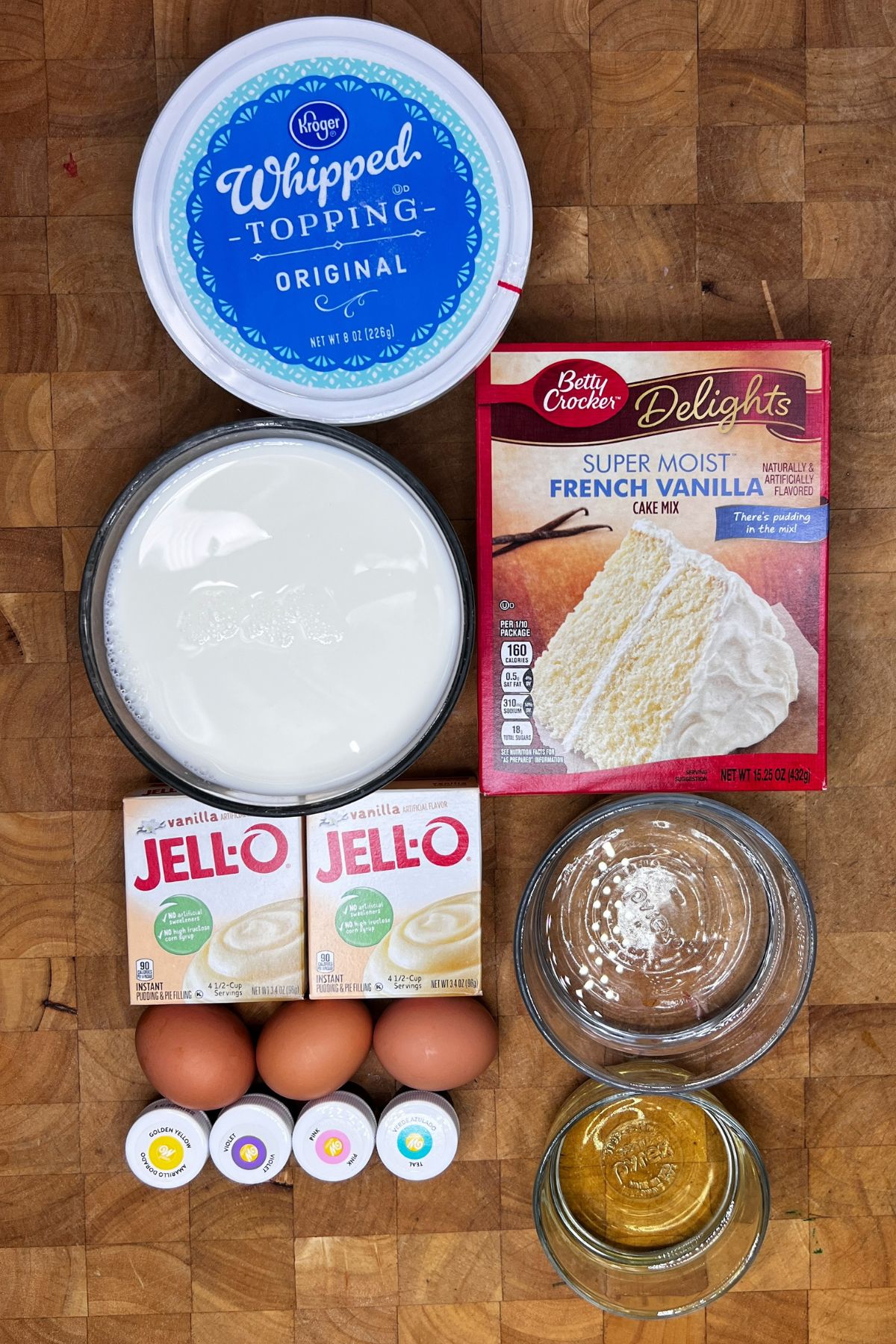 Ingredients for easter poke cake on a wooden table.