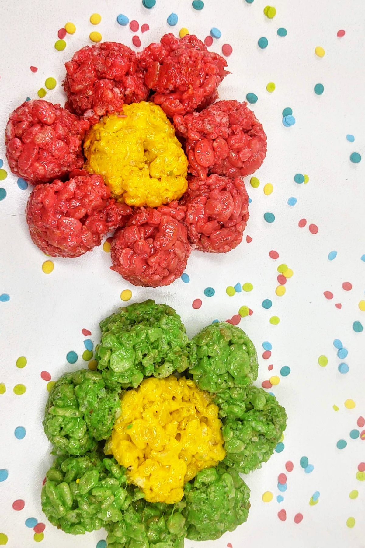 Flower rice krispie treats on a white table with sprinkles.