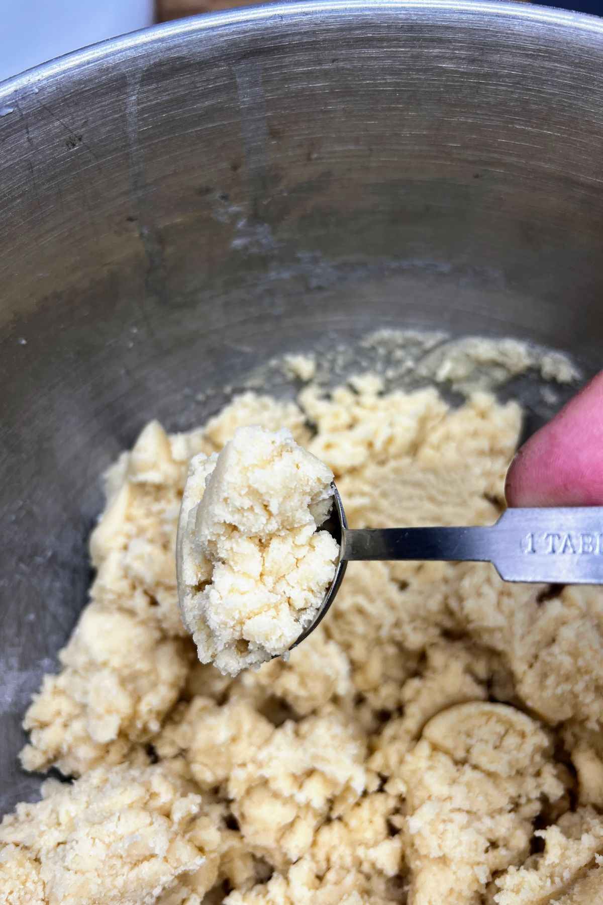Scooping sugar cookie dough into balls.