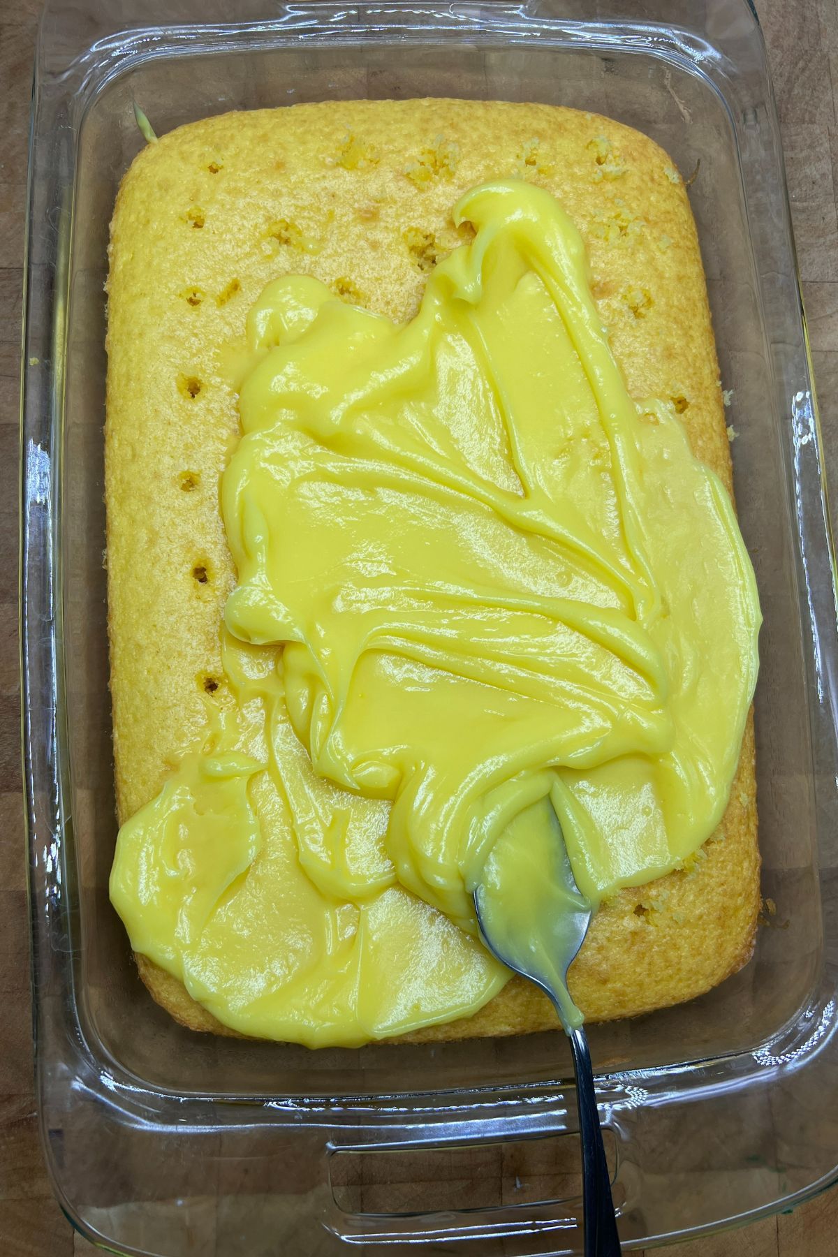 Spreading lemon pudding on top of lemon cake.