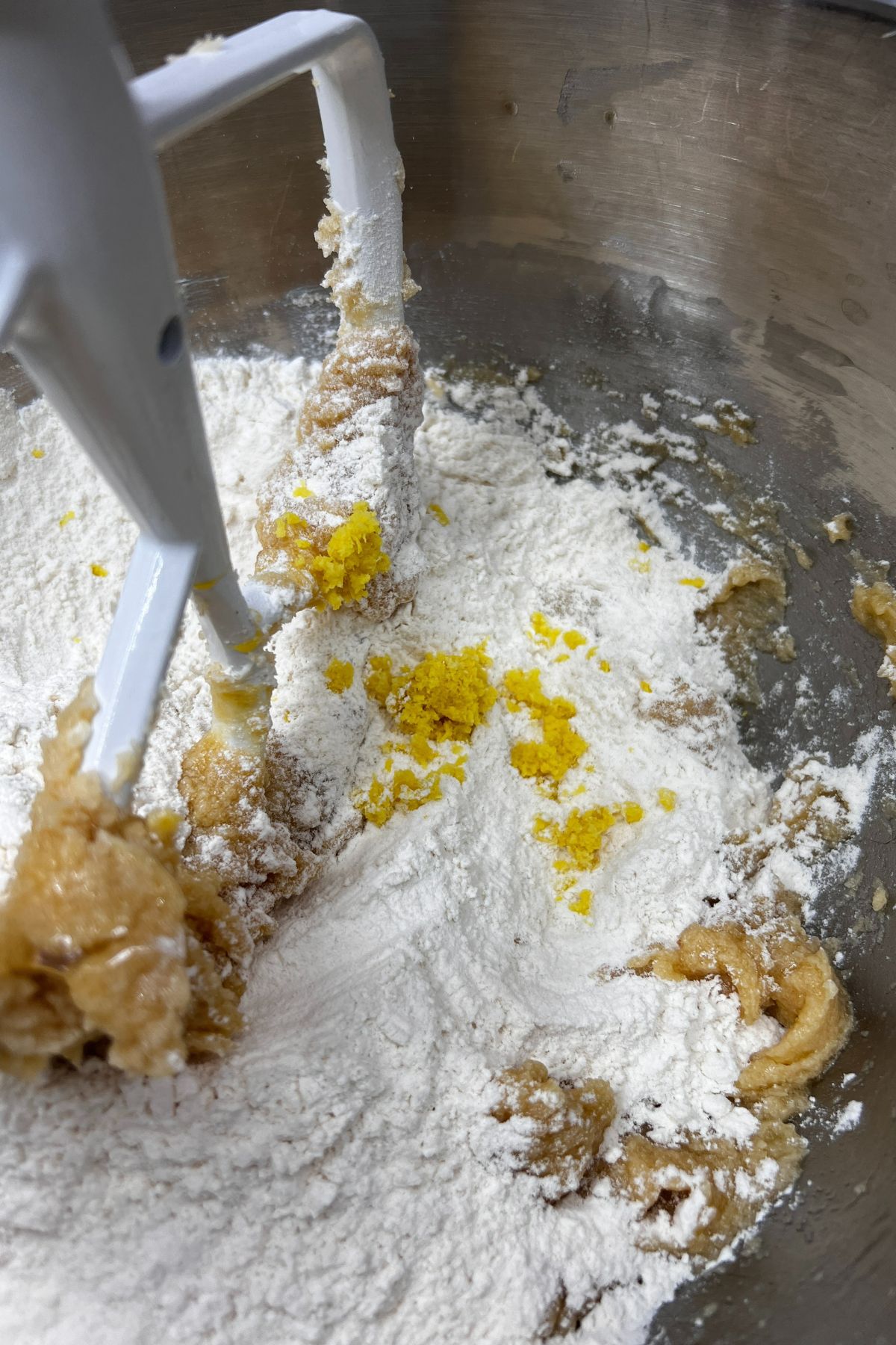Stirring in flour and lemon zest to cookie dough.