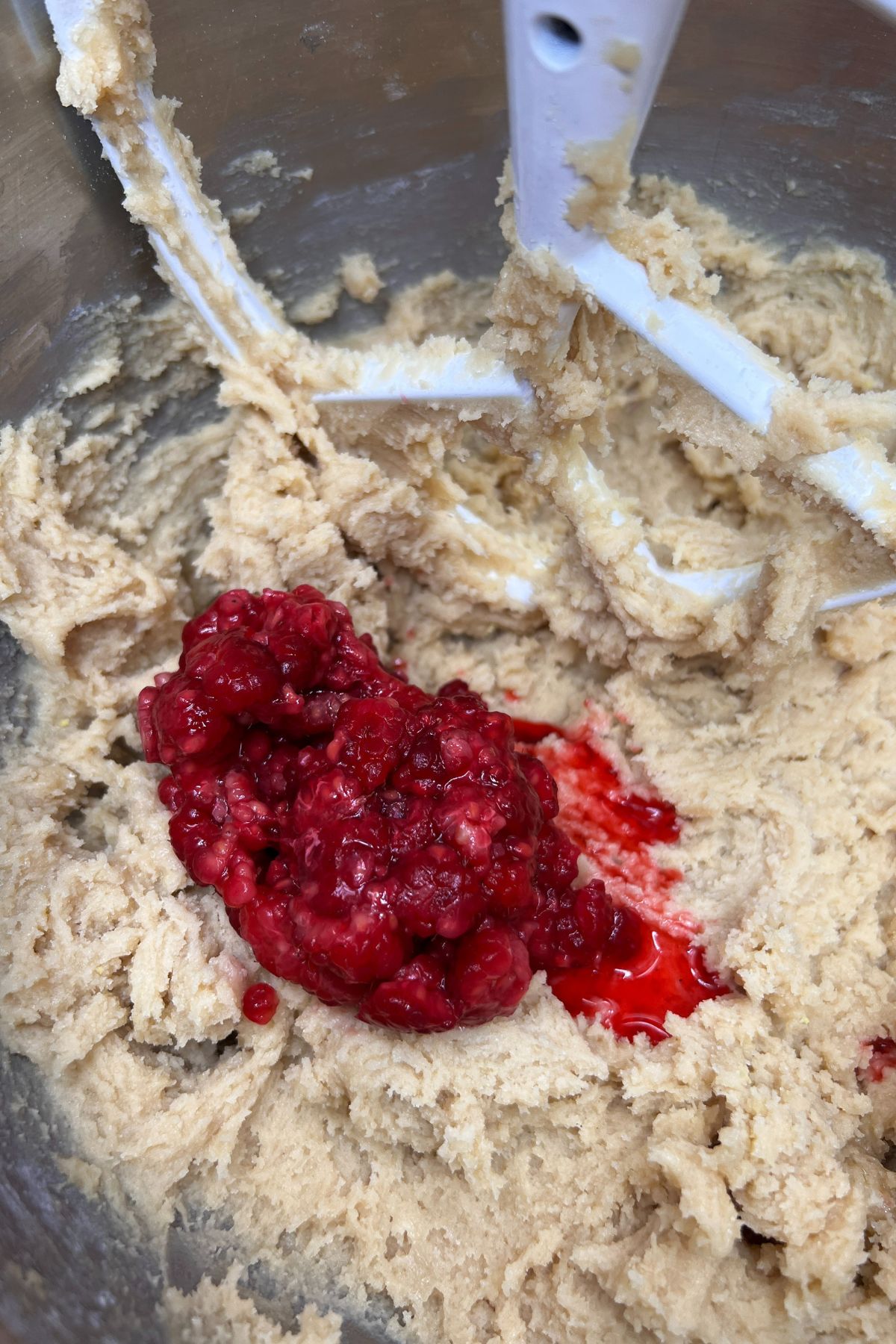 Adding raspberries to cookie dough.