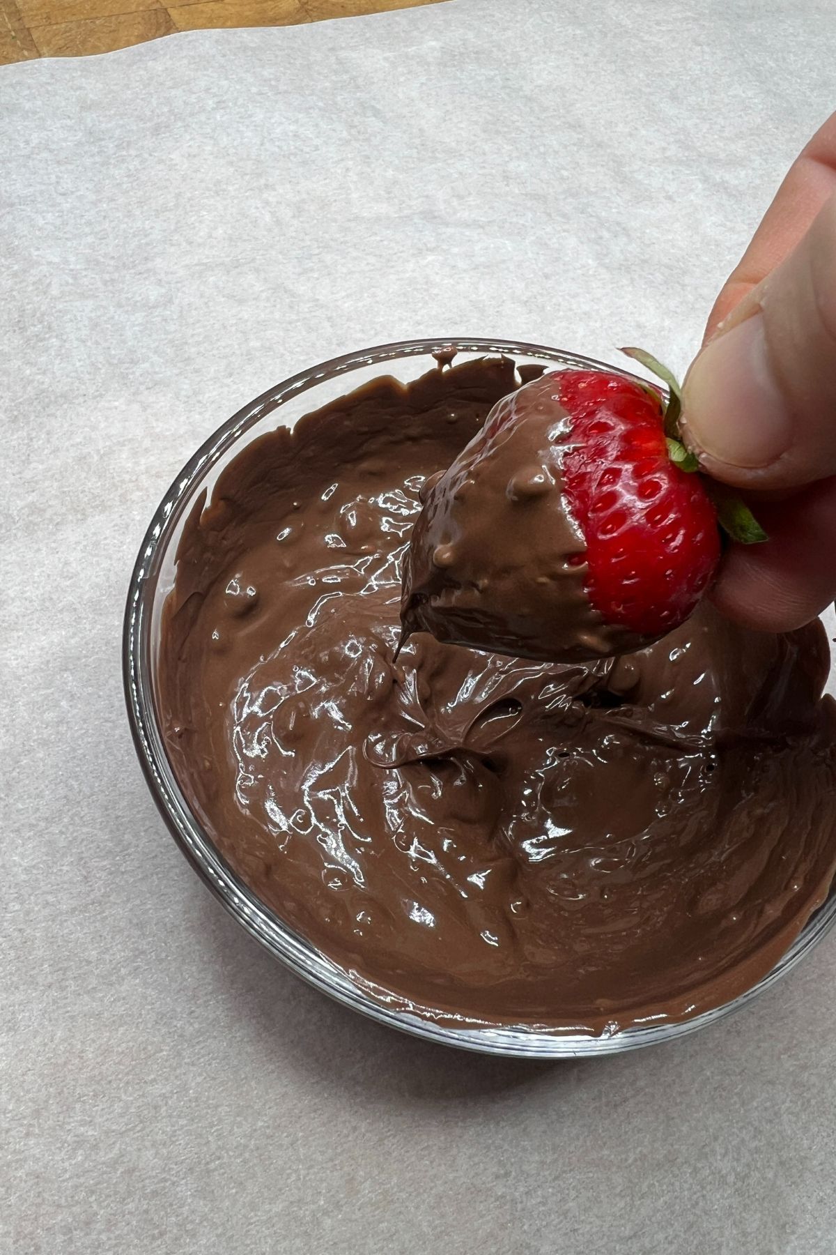 Dipping a strawberry into chocolate and nutella.