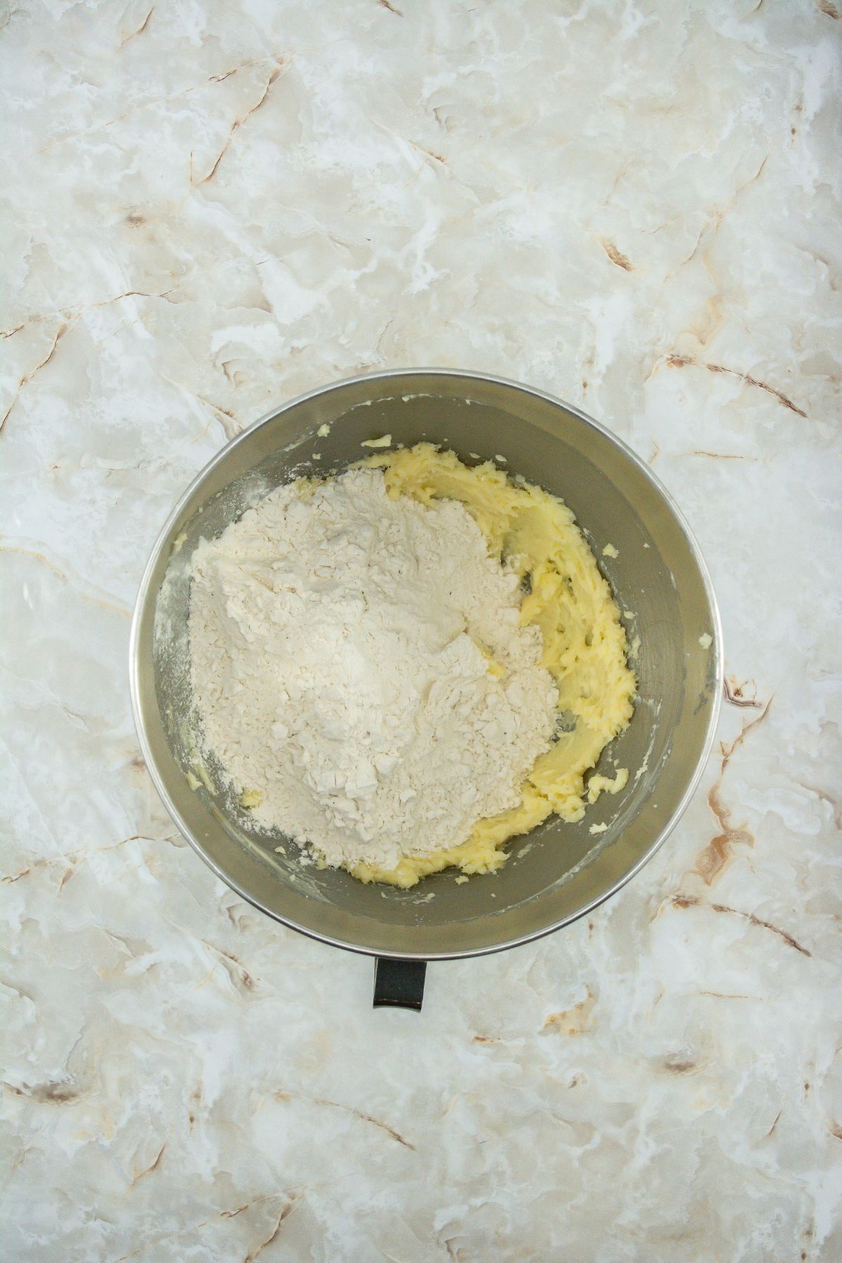 Cookie dough with flour in a mixing bowl.