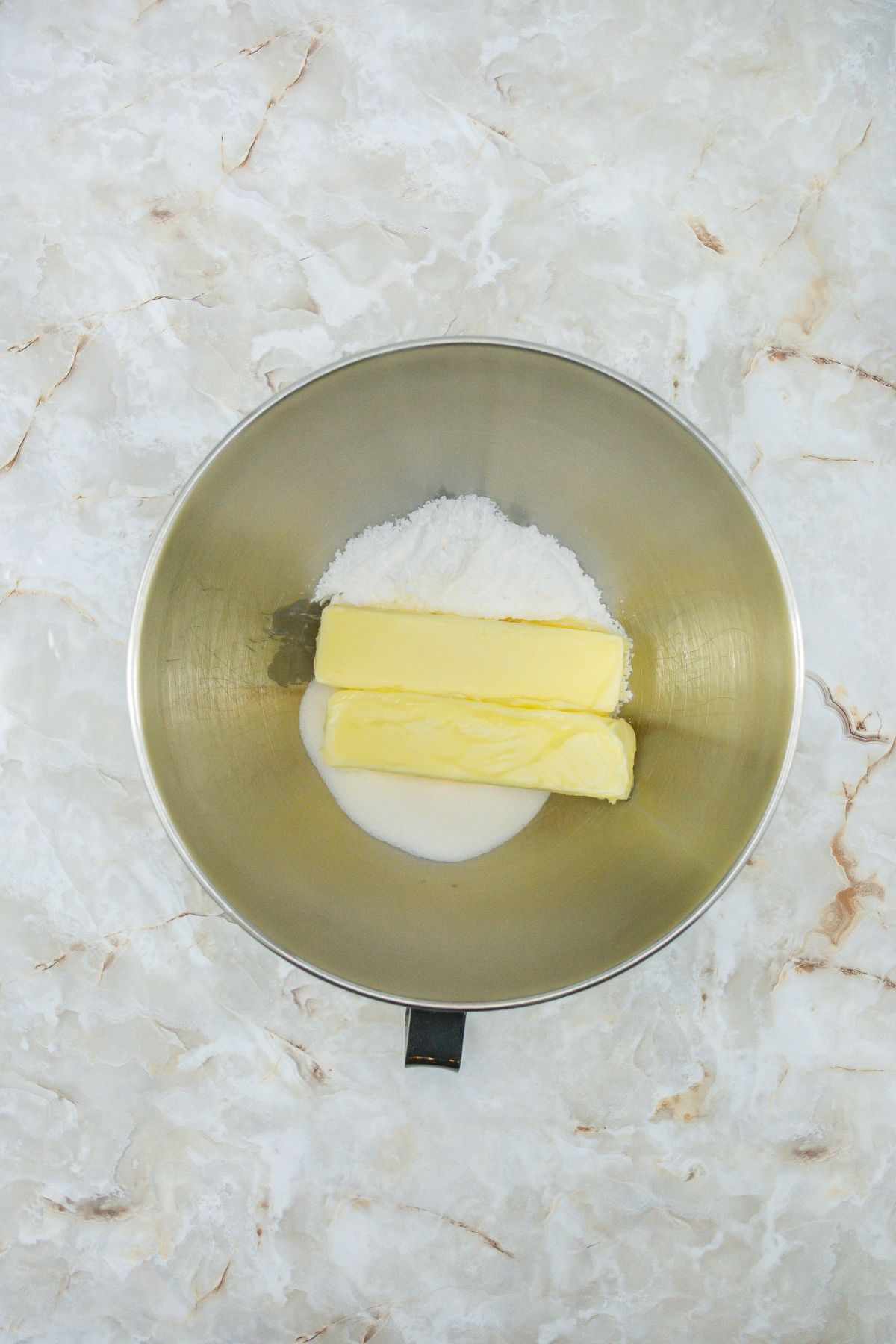 Softened butter and sugar in a mixing bowl.