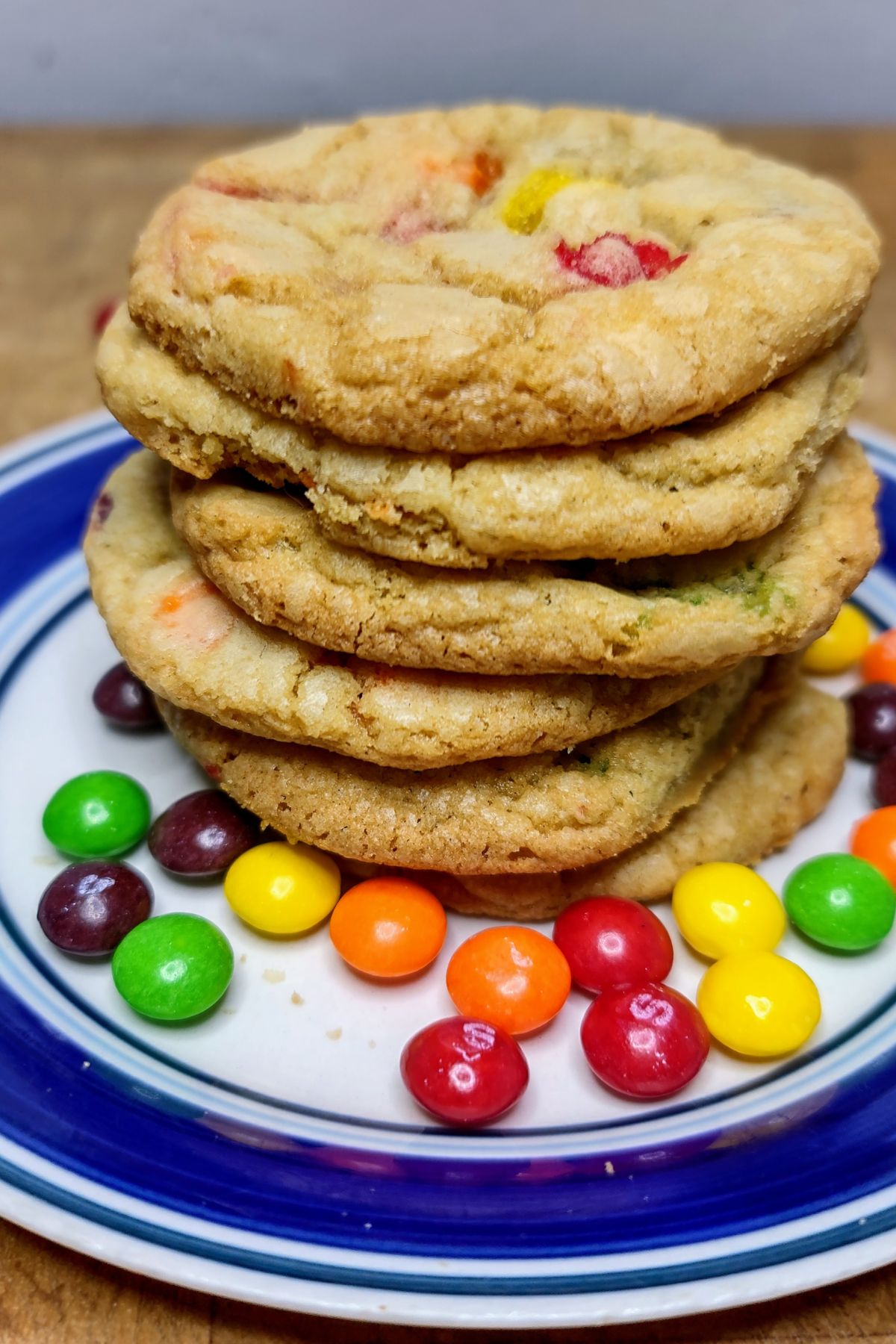 Stack of skittles cookies on a plate.