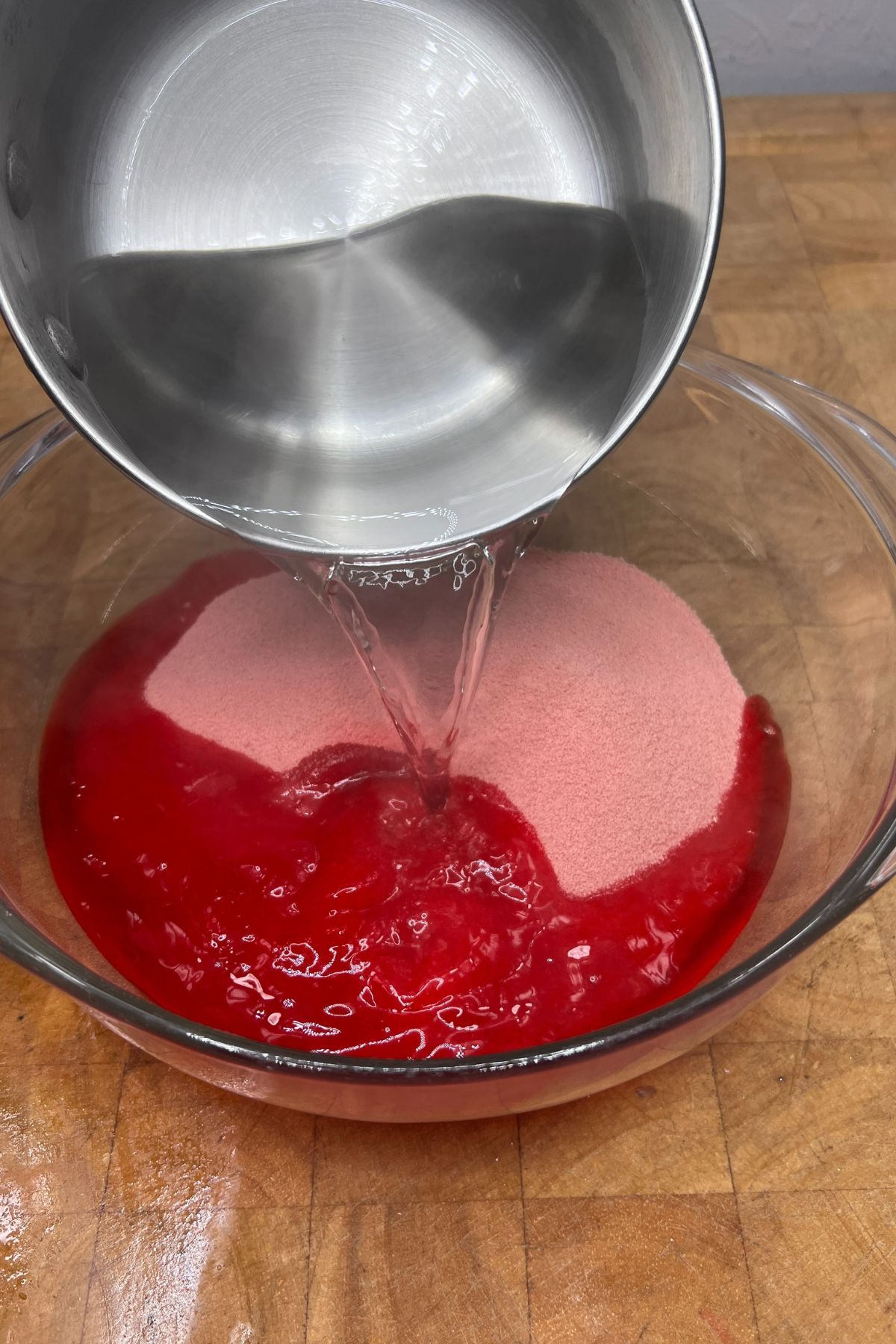 Pouring water into jello mix in a bowl.