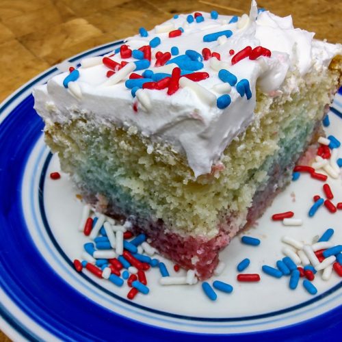 Slice of patriotic poke cake on a plate.