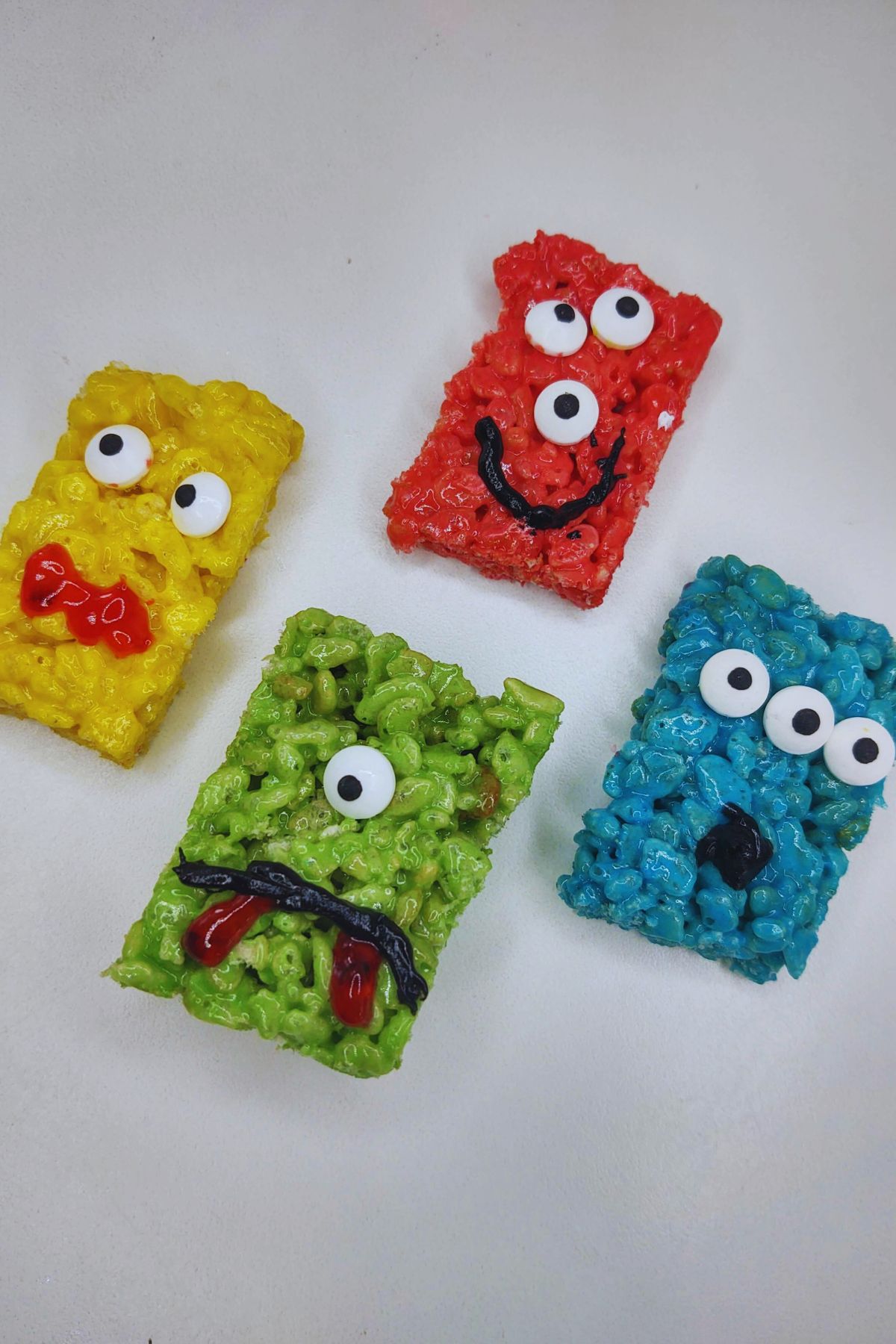 Monster rice krispie treats on a white table.