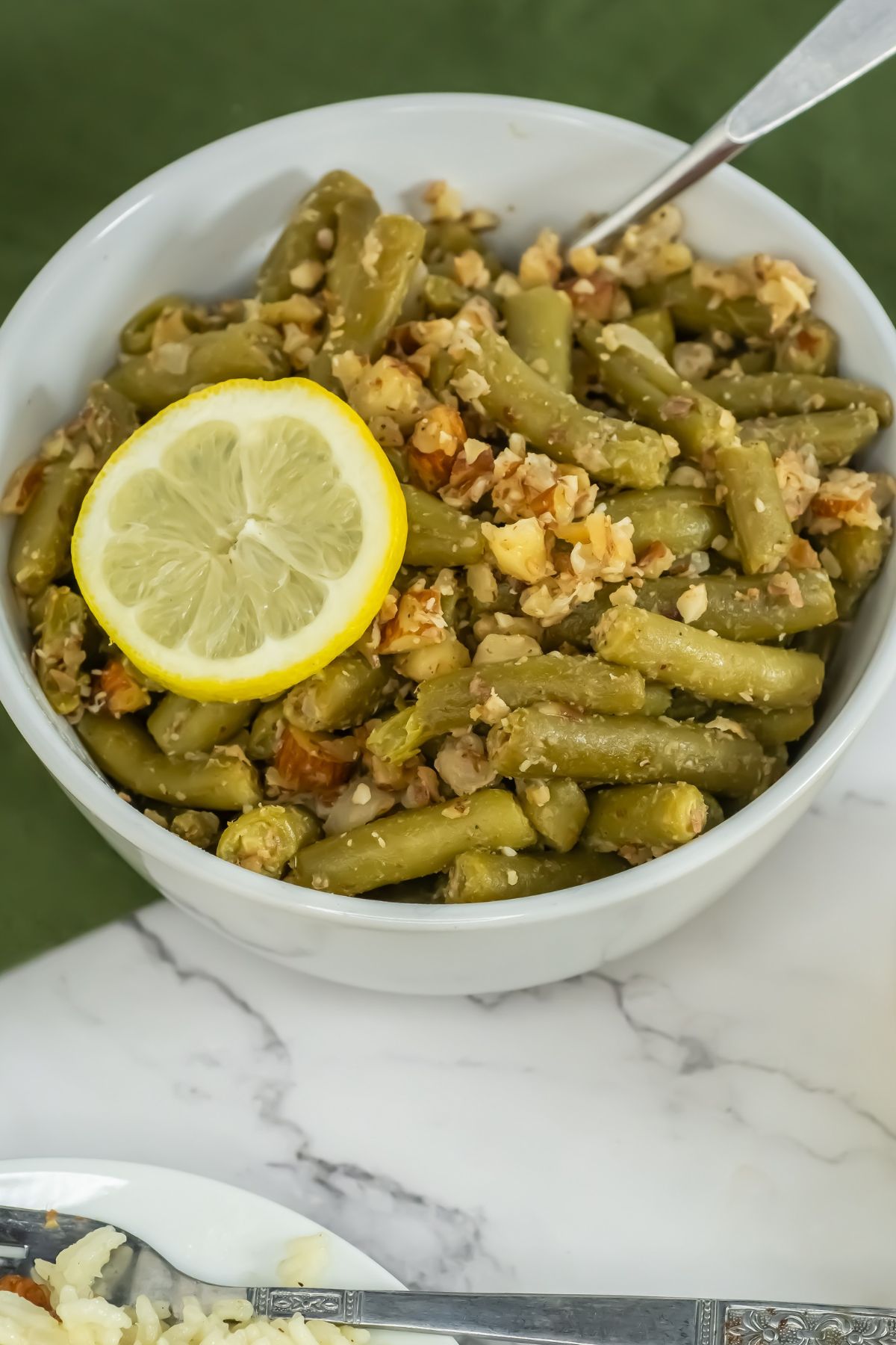 Canned green beans in a white bowl.