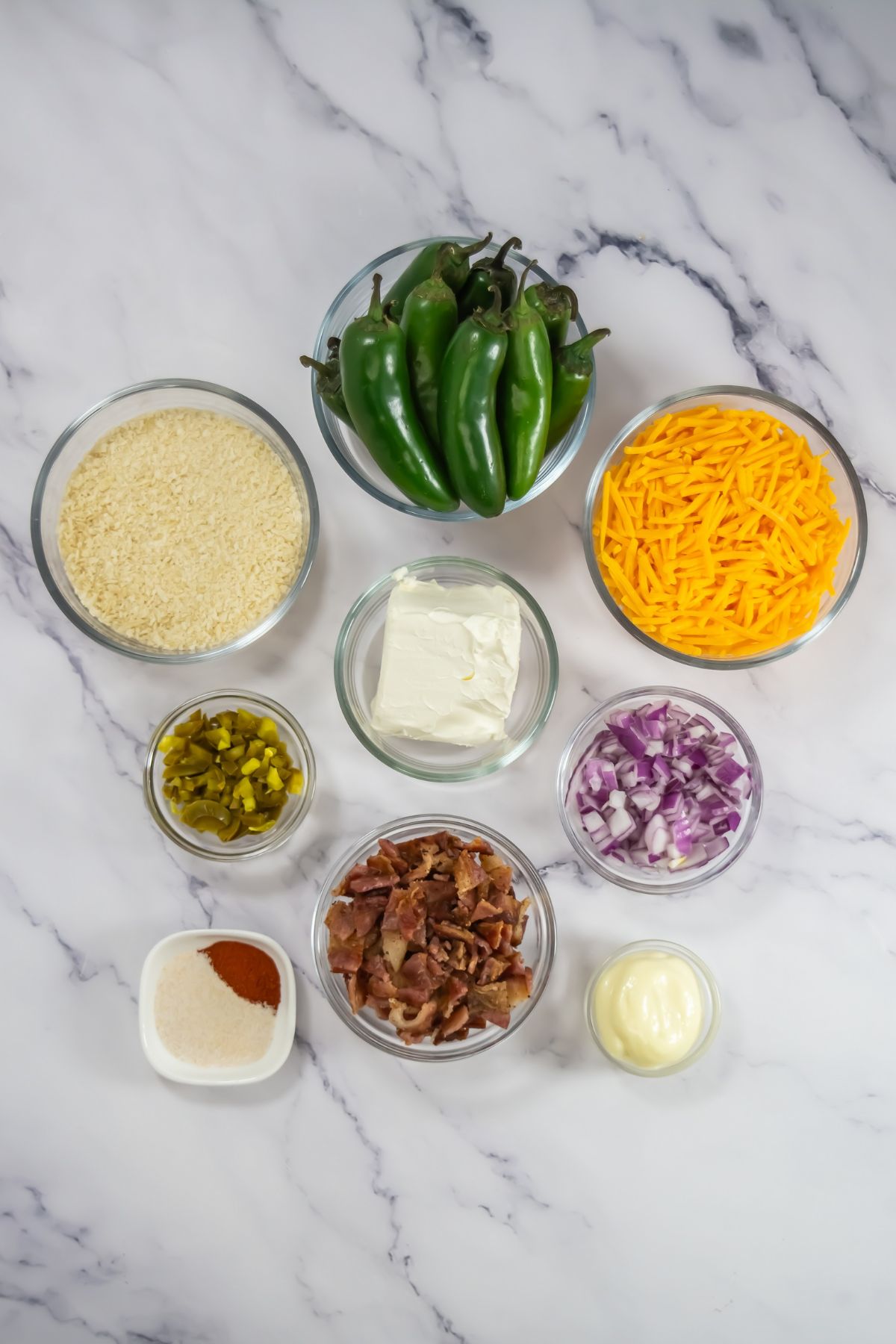 Air fryer jalapeno popper ingredients on a marble counter.
