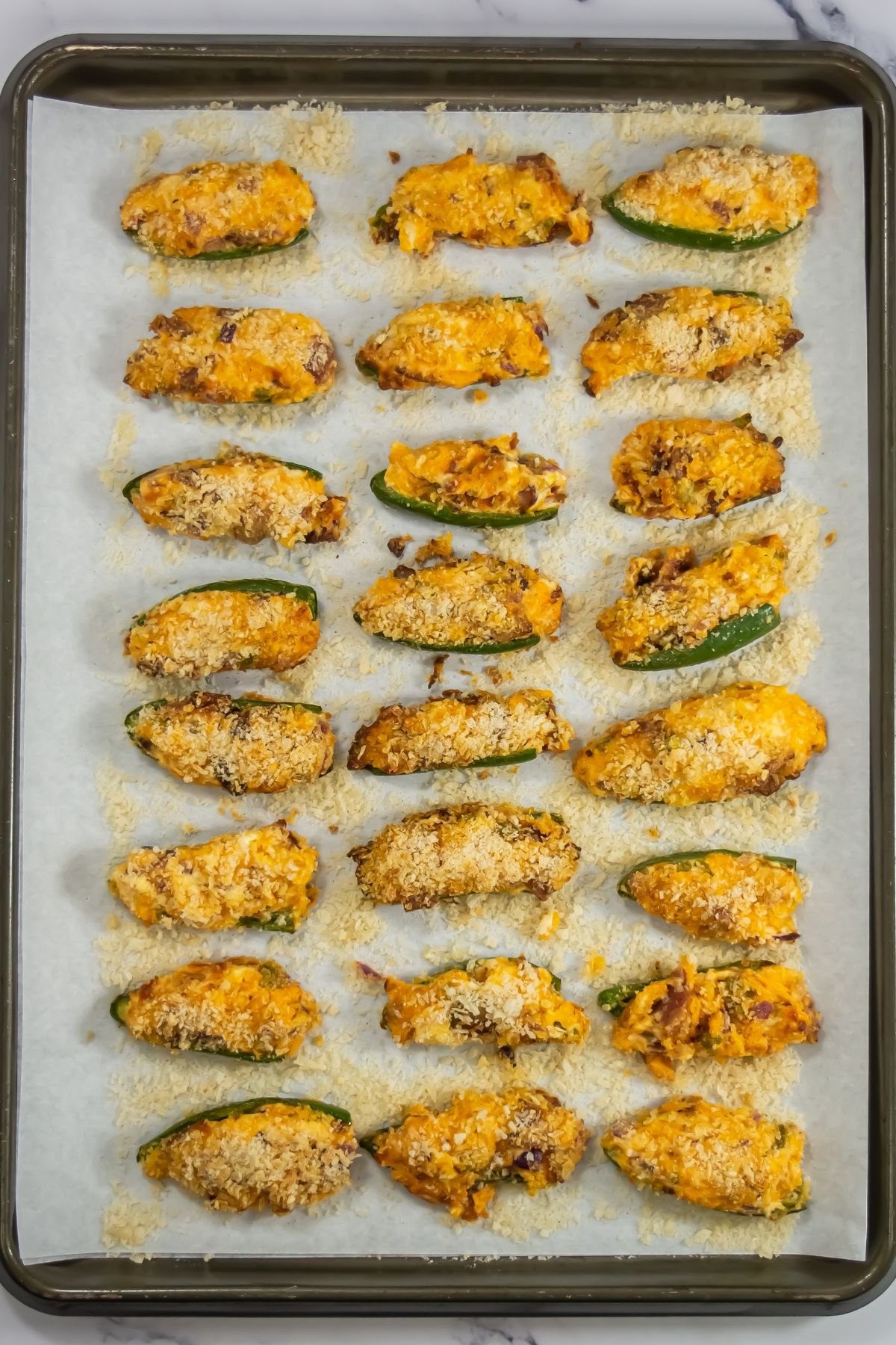 Jalapeno poppers on a baking sheet.