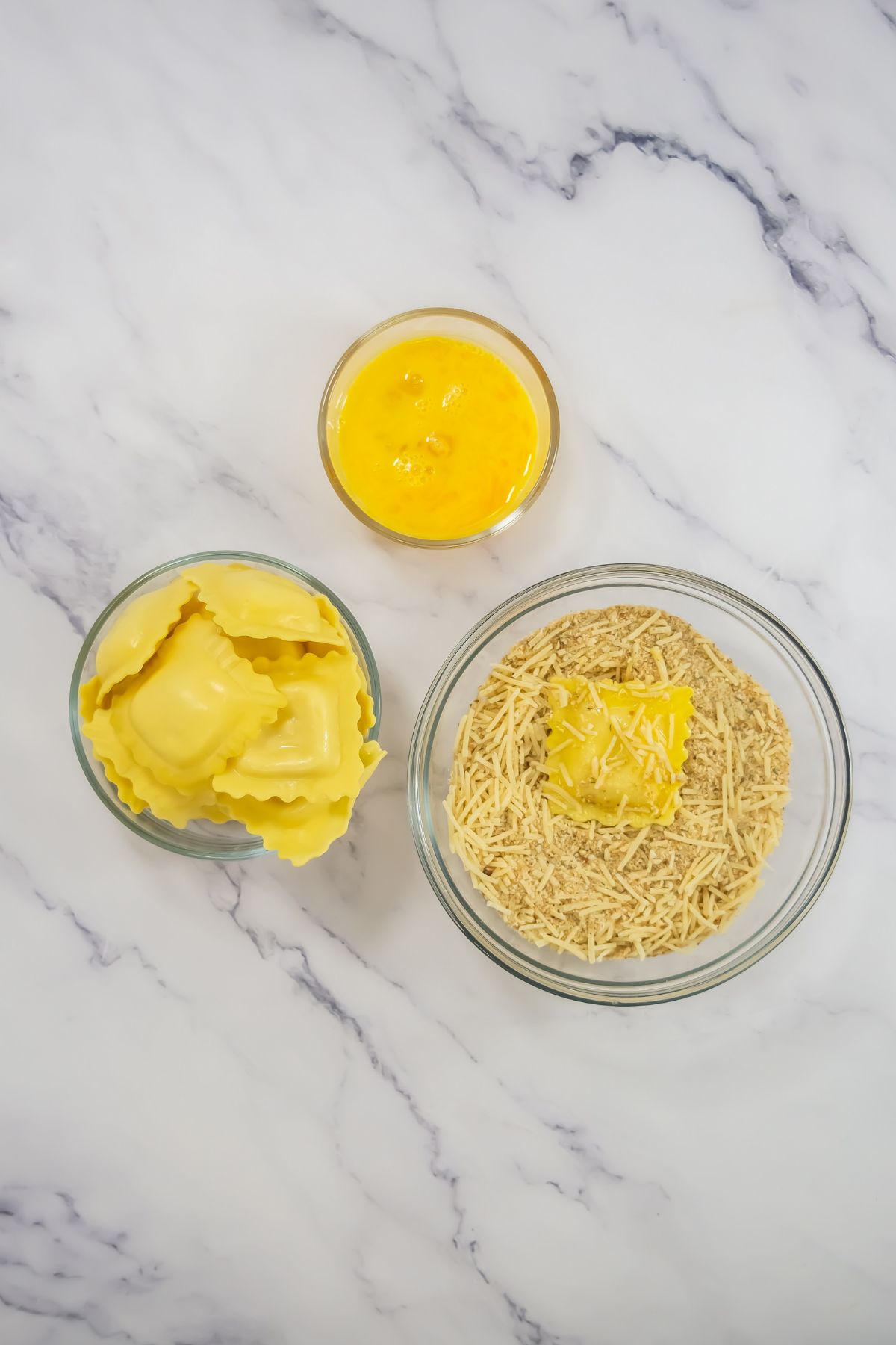 Dipping ravioli in breading mix.