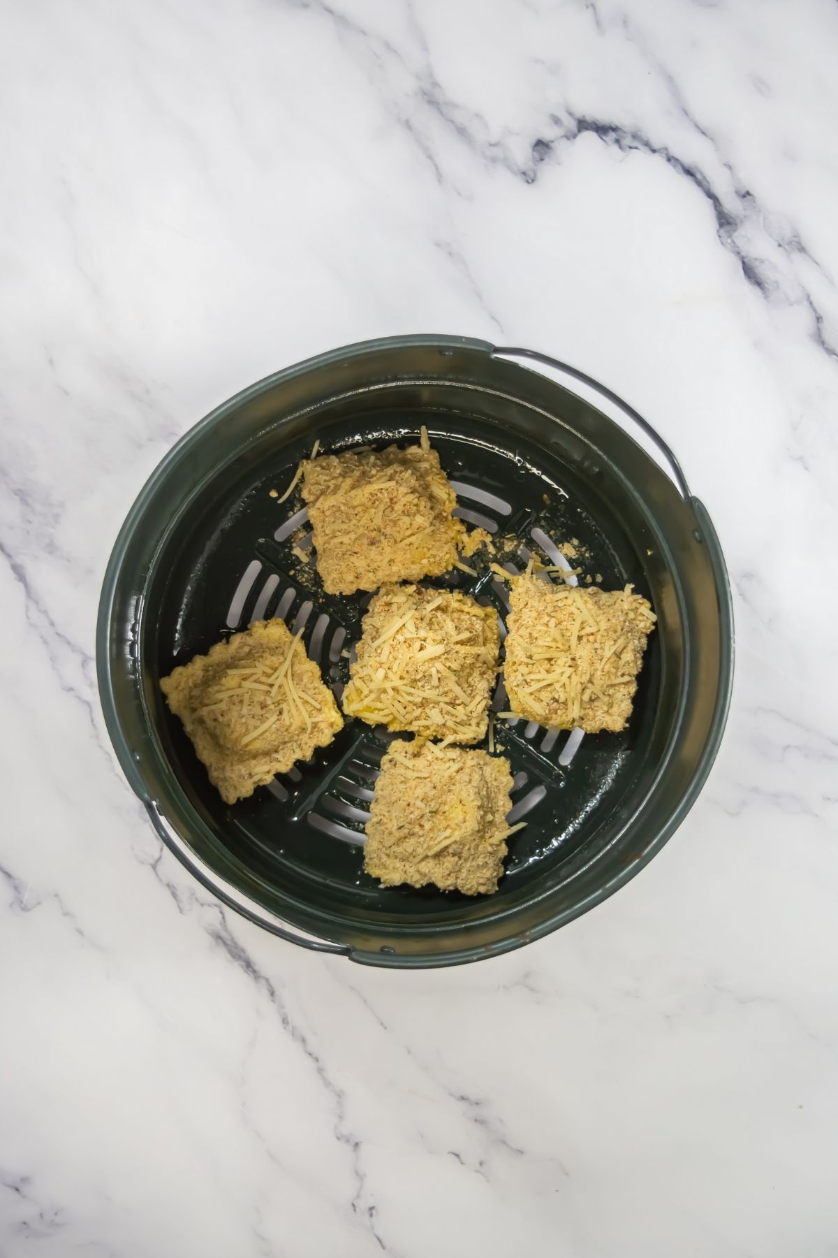 Breaded ravioli in an air fryer.