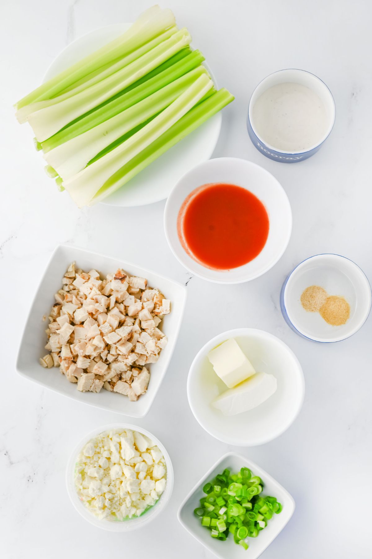 Buffalo chicken celery ingredients on a white counter.